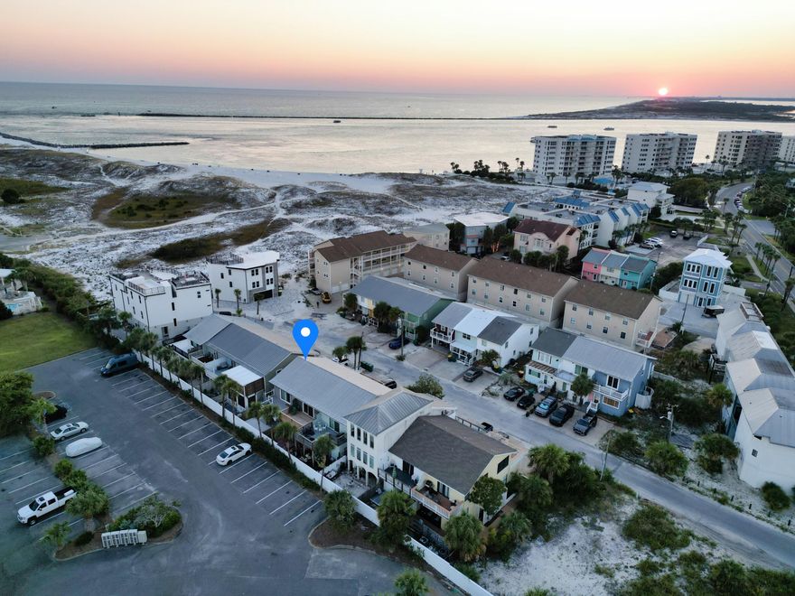 Newly renovated! New paint inside and out. Beautiful modern 2 bedroom 2.5 bath end unit townhome with easy beach access. Water view of the inlet and harbor. Perfect for a vacation rental, second home, or forever home. Located on a private street and LOW annual HOA fee of $355/yr to the master HOA (Holiday Isle Improvement Association). Thoughtfully designed bathrooms, LVP flooring throughout, 2 upper balconies, front porch and back patio area that offers plenty of space to spread out. NEW HVAC system, NEW water heater, spiral staircase from upper back balcony to lower patio. Impact rated windows/doors. Metal Roof. Solid custom kitchen cabinets with quartz countertops and large island. Zeroscape for easy exterior maintenance.