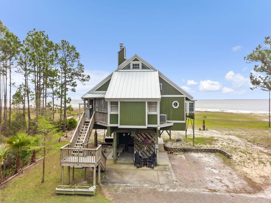 Discover the Forgotten Coast and its old-Florida nostalgia in this 3-bed, 3-bath, waterfront dream, tucked away in the quiet, coastal town of Carrabelle. Upon entry, you'll immediately be struck by unparalleled views of private beach and St. George Sound. The beautiful tongue and groove ceilings and wood floors add to the rustic charm of the property, creating a warm and inviting atmosphere. Between the loft bedroom balcony, 3 sunrooms, and the end of the dock, it'll be hard to pick your favorite spot for sunrise.The 3 outbuildings, each with electrical, provide plenty of space for your hobbies, while the three carports are perfect for covering cars, boat, RV, and tractor. Whether you are looking for the perfect retirement property, a weekend