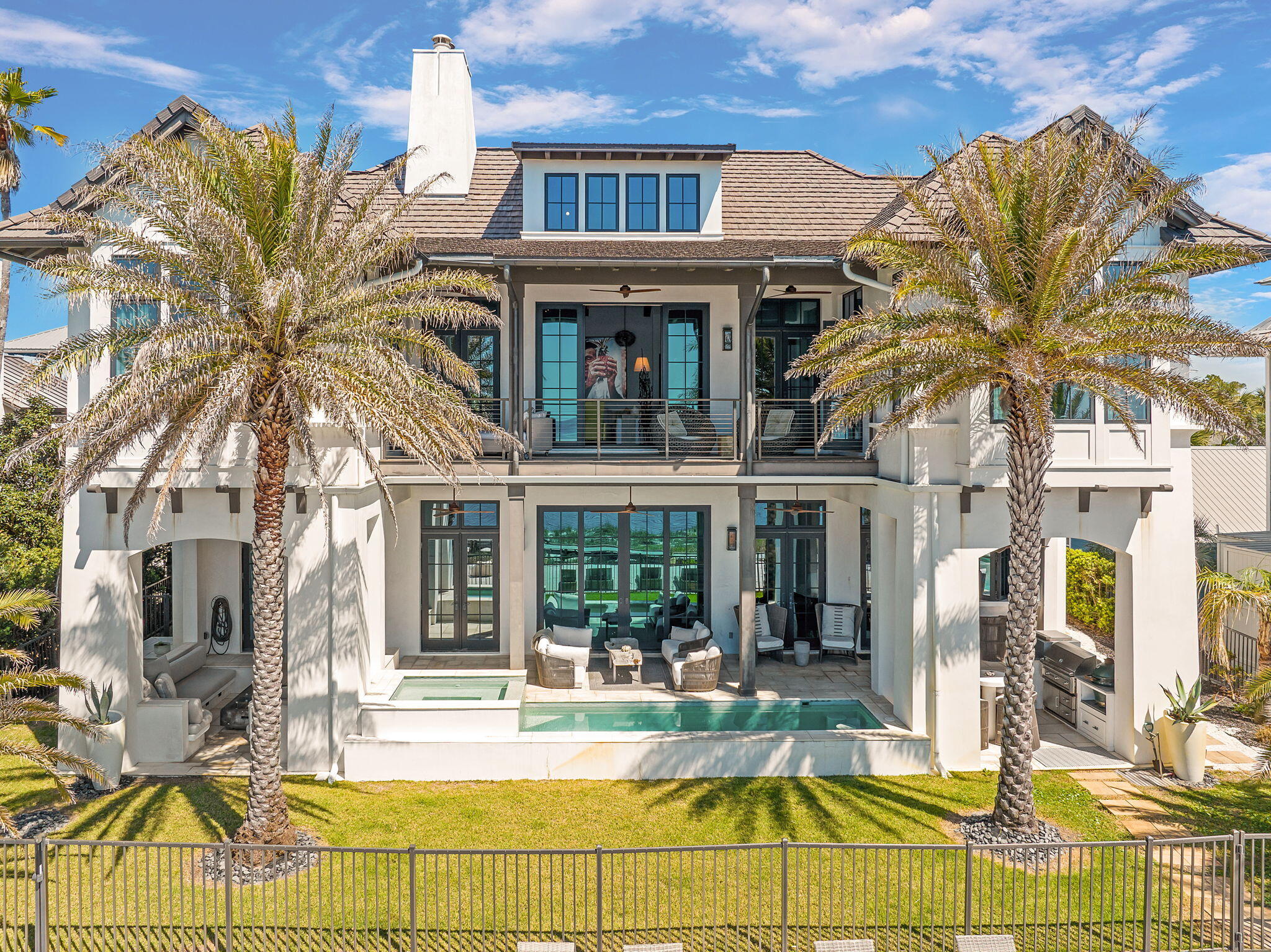 291 Garfield St., located in the iconic beach town of Grayton Beach is a true masterpiece. The custom home was expertly designed by renowned architect, Tom Christ and brought to life by an exceptional team of designers. Every element of this residence was intentionally curated, blending elegant finishes with a relaxed coastal feel that perfectly embodies luxury beach living. This custom home exudes the epitome of what a luxury beach home should be, but yet the design creates an overall feeling of relaxation. The private drive leads to a spacious parking court and impressive facade creating a true sense of arrival. As you step into the great room, your eyes twitch back and forth from trying to take in the unmatched views of the water with absorbing the interior beauty of the home. Light and reflections dance over the venetian plaster walls and ceilings. Expansive sliding glass doors blur the line between indoors and out, drawing in the sea breeze and creating an open-air coastal retreat with a Caribbean feel.
A quick glance to the left and you are staring at a custom chilled wine wall; a showcase for exotic wines and champagnes. The custom kitchen anchors the east end of the home boasting a custom La Canche range, custom cabinets and a sliding window opening the kitchen up to the outdoor cooking and dining area. Tadelakt countertops, an ancient Moroccan blend of concrete and plaster provide ample space for cooking, dining and entertaining. The home is an entertainers dream. The main floor is completed by a guest suite with a private entrance, a large pantry/washroom and a full sized powder bath. The powder bath has both an indoor and outdoor shower; perfect for rinsing off after long days at the beach or dips in the pool.
Upstairs you are yet again wowed by not only the incredible views of the beach and gulf but also by the spacious living area you are standing in. The room showcases soaring vaulted and beamed ceilings anchored by an oversized fireplace. Another set of sliding doors opens up to the large lounging porch overlooking one of 30A's treasures; Grayton Beach. The master suite offers an elevated sense of serenity with its own vaulted ceilings, water views, and spa-inspired en suite bath. Two additional guest suites branch off the living area on this level. The guest lounge and suite is a unique design feature not seen in other homes. This wing serves as yet another place to congregate and entertain around the custom bar and sitting area, while also providing additional sleeping accommodations. The bathroom in this wing is a design standout.
The home is a work of art, but functionally it was built like a fortress. Concrete block construction rests atop a number of deeply embedded concrete pilings thus ensuring long term strength and stability.
Outdoor living here is key with multiple sitting areas providing areas to both relax or entertain; all set against the backdrop of Grayton Beach. If you want to get your feet in the sand or dip your toes in the Gulf waters, take a few steps and there you are. Looking for an exercise option? Grab a paddle board and paddle around Western Lake, but be on the lookout for Bald Eagles, Herons, Blue Crabs or various species of fish.
When it is time to leave the confines of your personal luxury resort, you are steps away from "downtown" Grayton Beach. The world renowned Red Bar offers fresh seafood and live music nearly every day of the week. Chiringos, a fresh upscale 30A take on the beachside open air dive is a favorite for locals and visitors alike. Local favorites like Black Bear Bakery and Borago are just up the road. A few artist galleries and music venues are all within a short distance keeping the Grayton tradition of being a haven for those who create art and music alive.
From the home to the location, 291 Garfield is truly unmatched.