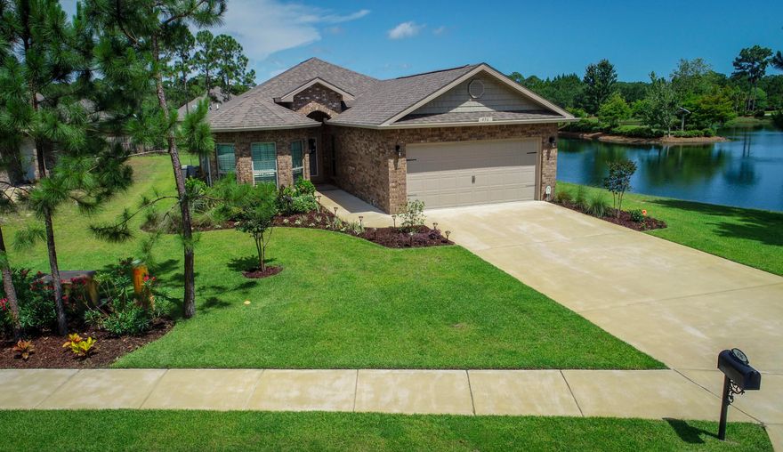 Almost new hardly lived in 4 bedroom/2 bathroom home strategically positioned on its premium lakeside lot to enjoy lake views from inside your home or your covered back patio. This home faces west to comfortably enjoy your private lakeside backyard without the afternoon sun. An open floor plan boasting a large kitchen & living area with desirable Master Suite separation from 3 Guest rooms. Home includes many upgrades such as white granite kitchen counter tops with a deep single sink & matching faucet, Master Suite walk-in tile shower, Custom Plantation Shutters throughout, full lawn irrigation with well water pump, gutters, alarm system, etc. An easy walk to Community Pool, Playground & Clubhouse. True ''Community Feel'' without beach tourist traffic, yet only a short drive to the Beach.