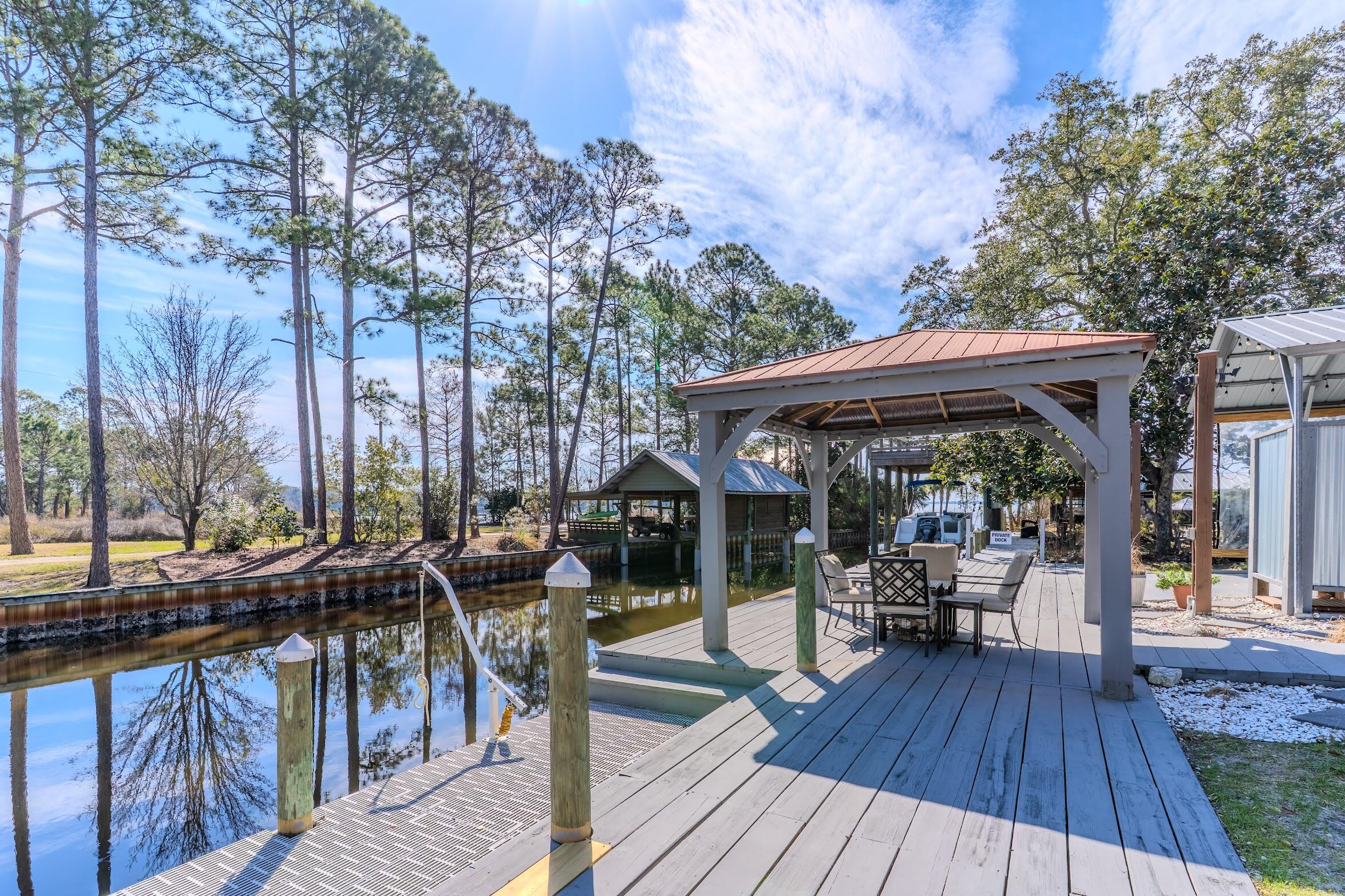 Discover this charming canal front home in Freeport, offering a serene and convenient boating experience just 2 minutes from the protected waters of Alaqua Bayou. This prime location provides easy access to the Choctawhatchee Bay and the Gulf of Mexico, with the Portland public launch only a 10-minute boat ride away. The property boasts a 65-foot dock with a 4-foot draw in winter and a 6-8 foot draw in summer, making it a true boater's paradise. The outdoor spaces are designed for ultimate relaxation and entertainment, featuring a gas fire pit, expansive decks, covered porches, an outdoor shower, and a hot tub. . The main house was fully remodeled in 2020, it offers 3 bedrooms and 2 full baths. An auxiliary building provides versatile living options with two bed alcoves, a full bathroom and plumbing and wiring for a future kitchen, plus a loft space ready for customization. The property also includes a workshop and shed, both with electricity, perfect for hobbyists or additional storage. This waterfront gem