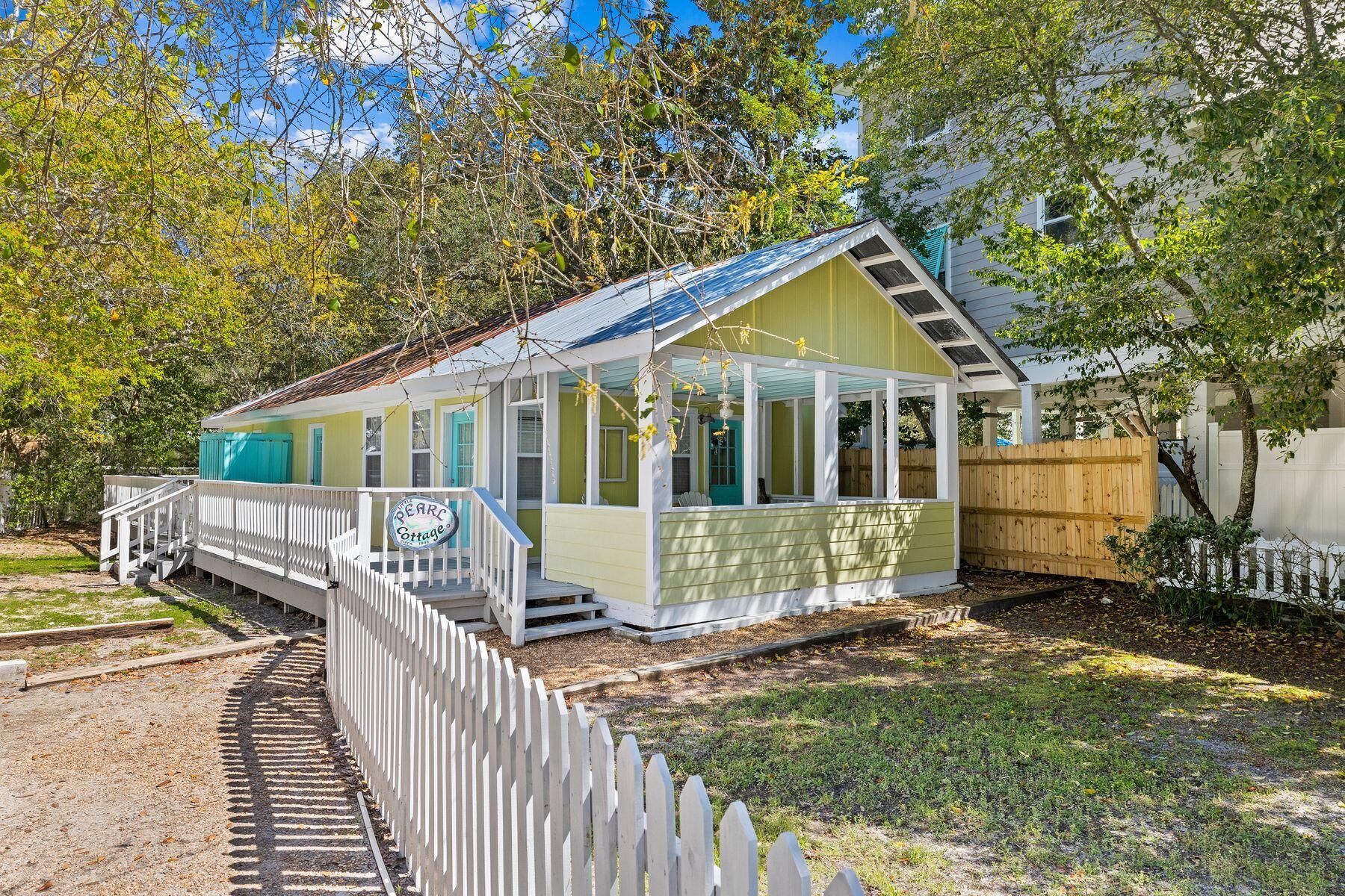 This delightful beach cottage is situated on a shaded lot just a short walk to the beautiful sandy beaches of Grayton Beach. A large wraparound porch and bright beachy decor set the tone for this desirable vacation home. The open living room is light and airy with white walls, LVP wood flooring and a shiplap ceiling. There's ample space for entertaining in the dining area or putting your feet up in the laid-back sitting area. You can easily add a daybed to this spacious area to accommodate additional overnight guests. The open kitchen is well-appointed and the wood-topped breakfast bar provides a natural place for hanging out with those in the kitchen. Two bedrooms have white shiplap walls creating a beachy ambiance for resting after a busy day at the beach. The outdoor shower allows guests to rinse off sandy feet before heading indoors. An additional bunk nook also houses the essential stacked washer-dryer for managing towels and beachwear. The rear of the cottage has a large covered deck with ample space for a dining table and lounge chairs.The pet-friendly fenced lot is ideal for families and pets, and there's parking space for up to three cars. You'll find many excellent restaurants, boat charters, and beach access, all within easy walking distance. With no HOA fees or restrictions, this unique beach cottage in Grayton Beach is a fun place to make memories.