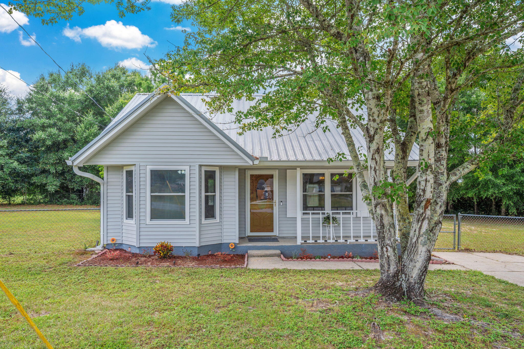 DELIGHTFUL FLORIDA COTTAGE! For those in pursuit of a starter home or a peaceful retirement retreat, this property is an ideal choice. It boasts a move-in ready status. The third bedroom offers versatility as an office or family room. A covered patio provides a serene setting for relaxation and outdoor entertainment. The expansive, fenced backyard includes a yard building for convenient tool storage.