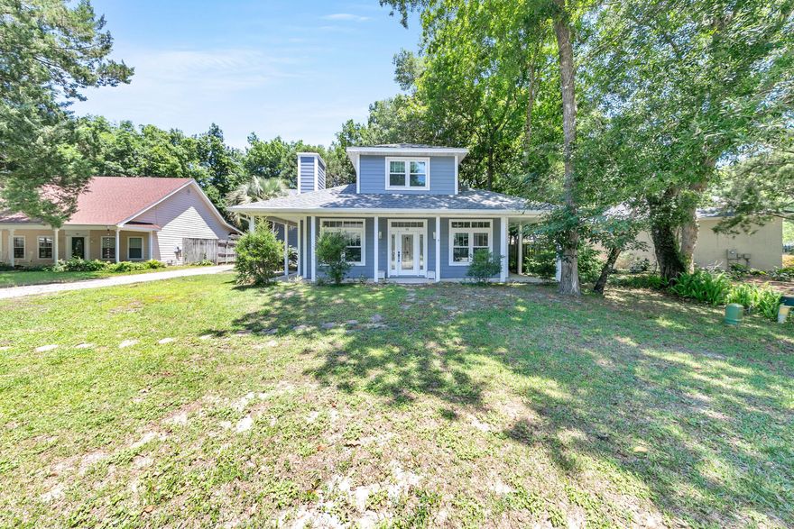 A large, wooded lot, separate two-car garage with apartment suite, multiple upgrades, and peaceful location convenient to both the beach and bay - this charming home checks all the boxes! Nestled on a quiet street along the Choctawhatchee Bay in a non-short term rental neighborhood, the primary home features 2BR, 2BA plus an office that could function as a third bedroom while the separate apartment offers a kitchenette, full bathroom, and its own heating/cooling system. A wraparound front porch welcomes you into a lovely living space with fireplace, hardwood floors, crown molding, and transom windows for natural light. The updated kitchen with adjacent dining space offers new stainless-steel appliances, granite countertops, soft close cabinets, and a tile backsplash.
