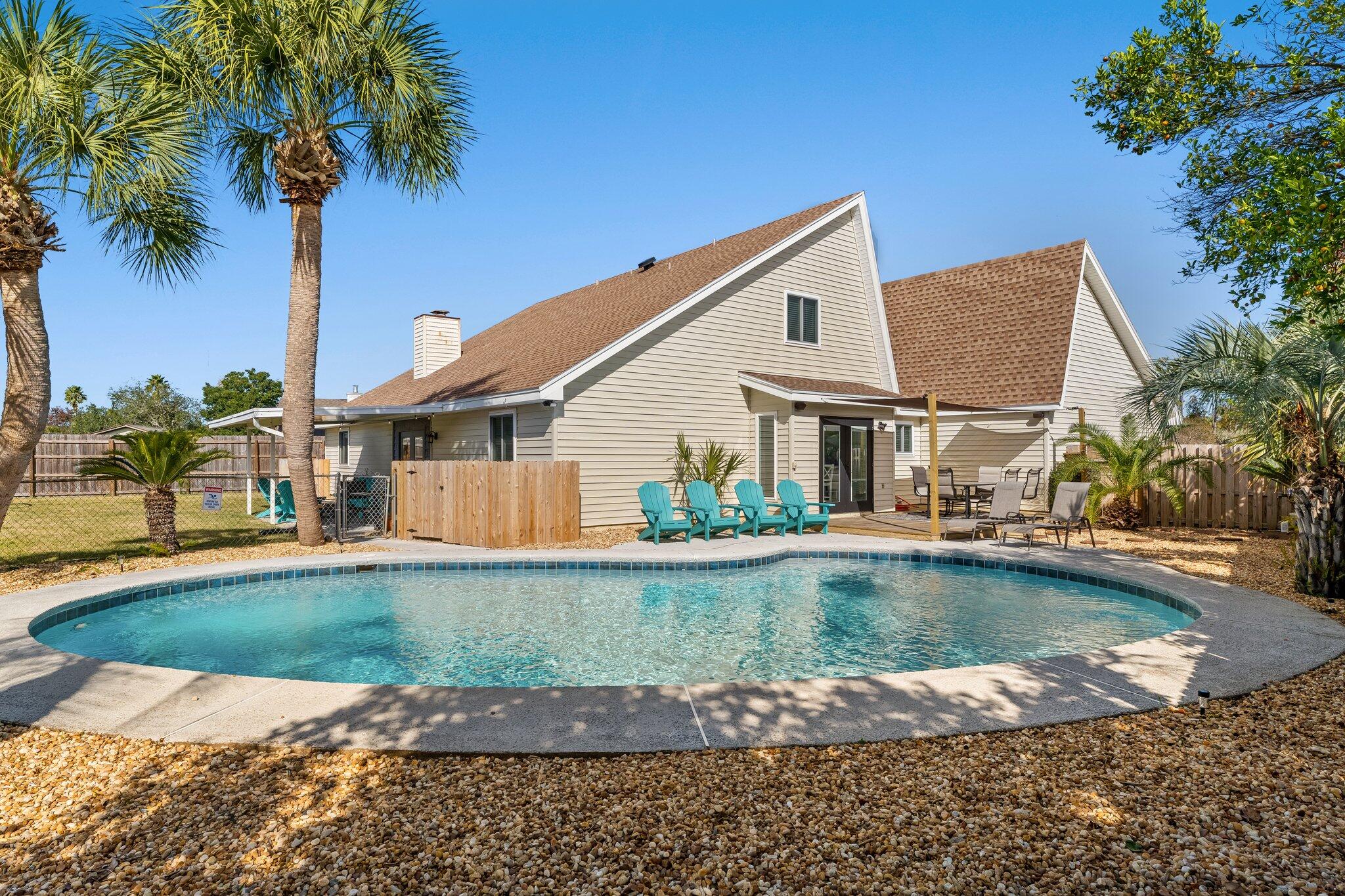 Welcome to your new Panama City Beach Home, complete with all amenities to live the beach lifestyle to the fullest! This renovated four-bed/three-bath home features vaulted ceilings with an expansive open feel--plenty of natural light, and 2260 square feet of living space. Every detail has been taken care of to make this your future home or vacation investment property. Short-term rentals are allowed, Rental Projections of $80+/yr and No HOA fees. All new furniture inside and out, linens, kitchenware and the bicycles in the garage, to make this home the perfect vacation destination for large families. This home is a short golf cart or bike ride to the beach! The renovation upgrades inside this home include: All new hurricane-impact windows, New 6 panel doors, All of the tubs have been resurfaced. New washer/dryer & hot water heater. New vanities in upstairs bathrooms. As well as fresh paint throughout. The renovations outside the home include: Pool resurfacing. A new pool pump. A pool heater, fresh sod, new landscaping and updated sprinkler system. All the work is done for you. In addition, the living room features a fireplace for those rainy, cozy days. Additional home features include the kitchen with granite countertops, plenty of cabinet space, a pantry, and newer stainless-steel appliances. Other features of this home include storage closets and a separate laundry room off the kitchen leading to a 2-car garage. There are two bedrooms, a bathroom downstairs, and two bedrooms with two full bathrooms upstairs. Outside you have a large fenced backyard with a covered patio and an open deck. Not to mention the beautiful heated inground pool and children's playground.