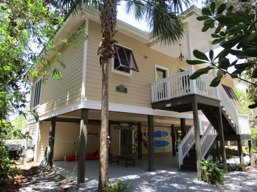 PRICE REDUCED ANOTHER $30 K! Well-maintained Florida cottage on Tucker Bayou in Historic Pt Washington! Nestled on over 1/2 acre of beautiful oaks, pines, red maples and magnolia trees. Ground floor consists of over 1,000 sq' covered parking, 2 separate enclosed dry storage rooms, covered patio and cooking area, open patio/decks,fire pit for outdoor enjoyment and entertainment. Recently rebuilt walkway and dock with boat lift. Water depth at dock averages 2-3'. House features include custom Spanish Cedar exterior shutters and front door, new colonial oak engineered wood flooring, Andersen doors and windows and surround sound throughout. The 2nd level has an open kitchen with breakfast bar that bar flows into dining/living space opening onto screened porch with open side decks-