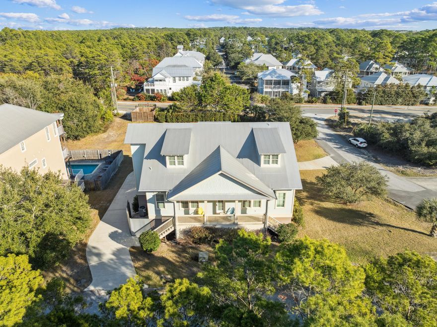 Discover exceptional coastal living in this custom-built four-bedroom, four-bath home offering 4,115 square feet of total living space and a layout rarely found along 30A. Set on a quarter-acre lot backing up to South County Highway 83, the property enjoys a large green-space buffer for added privacy and sits on one of the higher-elevation areas along 30A, providing an added sense of security, privacy, and coastal breezes -- all within a short walk to the Blue Mountain Beach access, local restaurants, shops, and Scenic 30A pathways.  The main level features a bright, open-concept design with abundant natural light and quality finishes. The spacious kitchen and living areas are ideal for entertaining or relaxing after a day at the beach.  A truly unique highlight is the walk-out basement, an uncommon feature in this area. It includes a one-bedroom lock-out apartment, perfect for guests, extended family, or potential rental income.  Car enthusiasts or those needing substantial storage will appreciate the oversized open garage, which accommodates up to four vehicles and offers additional room for beach gear, bikes, or a workshop. With its rare architectural features, generous living space, and prime location close to everything Blue Mountain Beach offers, this home strikes the perfect balance between convenience, privacy, and coastal charm.