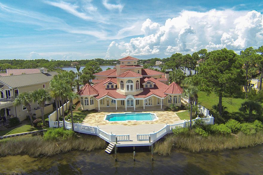 Experience unprecedented vistas from this outstanding bay front manor optimally located within the pristine gated community of Bay Point. This home has undergone a major renovation and masterful re-design including a new roof. Panoramic water views abound from the moment one enters the foyer with it's impressive 35' ceiling and vertically cascading balustrades that provide a grandeur that is unmatched. This open floor-plan concept is ideal for entertaining with highly functional living spaces spanning the first level with each space encompassed by beautiful floor to ceiling glass windows perfectly framing endless views of Grand Lagoon & Bay Point Marina.