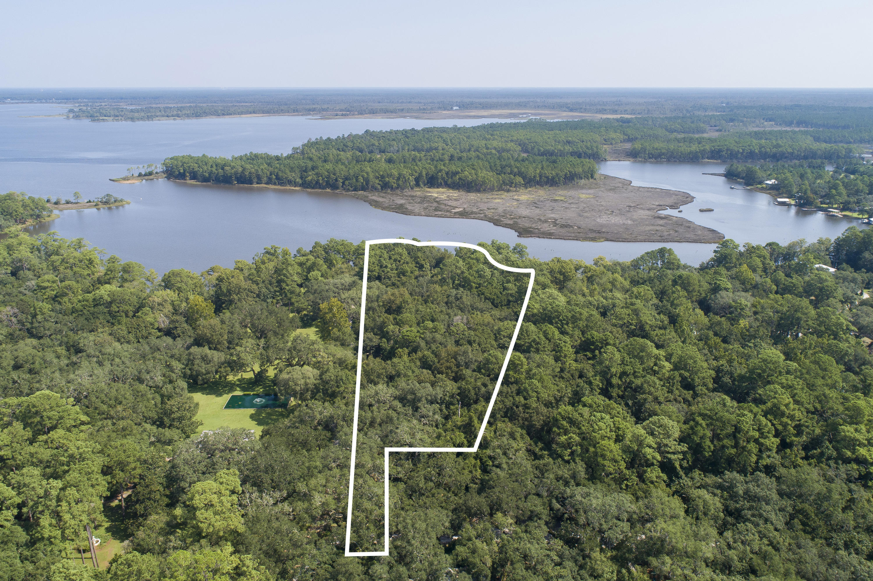 This is a one of a kind piece of land in Pt. Washington which is made up of two parcels totaling +/- 6.68 acres with 500+ feet of water frontage along Tuckers Bayou and bordered by Eden Garden State Park to the west. The majority of the land south and east of the property is also state forest. This is an ideal property for a private estate or the perfect land to develop with the allowed density of up to 8 units per acre.