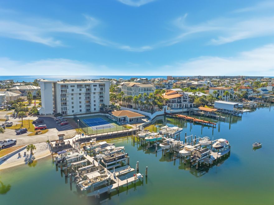 Welcome to Dolphin Point Penthouse 703A, a premier west corner residence on Holiday Isle in Destin. Offering sweeping harbor views & unparalleled resort living. INCLUDES 32' Slip #27 (10klb lift) w/ optional 2022 Key West 263 FS available!Meticulously appointed throughout with cherrywood cabinets & built-ins, granite, trey ceilings, upgraded electrical, systems & appliances - one of the largest  floor plans in the complex with 3 bedrooms & 2 bathrooms at 2280 sq ft. Third bedroom currently used as home office. Enjoy morning coffee & evening sunsets off the master balcony; overlooking the tennis courts & marina.Unit also includes large exterior storage room located on the 7th floor. Schedule your private your today and experience for yourself highly coveted Holiday Isle living! Dolphin Point is a luxury gated community situated on Holiday Isle in Destin.  The complex features a large, seasonally heated swimming pool (located behind Building C), a waterfront clubhouse (w/full kitchen - located behind Building A), grilling area, tennis & pickleball courts, marina (Slip 27 deeded to Unit 703A), paddle board & kayak storage, deeded community beach access, golf cart parking available, elevators, water taxi available and 24 hour security.