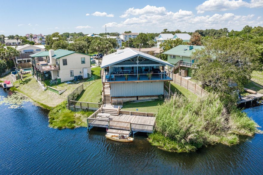 Amazing lake front home with a view of the Gulf of Mexico! This 3 bedroom 2 bath home sits just 1.5 blocks from the beach. This home offers an exposed beam cathedral ceiling in the upstairs great room offering panoramic views of the water. Step out onto the wrap a round balcony to enjoy the gulf breezes and views. This home features laminate flooring, built-in entertainment center, granite counter tops, and stainless steel appliances. The upstairs features two bedrooms and a bath and the downstairs has a bedroom and bath, laundry, and extra storage space. The large 15x29 private dock is a great place to enjoy fishing, kayaking and outdoor living. This fantastic home is tucked in the quiet west end of Panama City Beach yet close enough to the many activities this area has to offer.