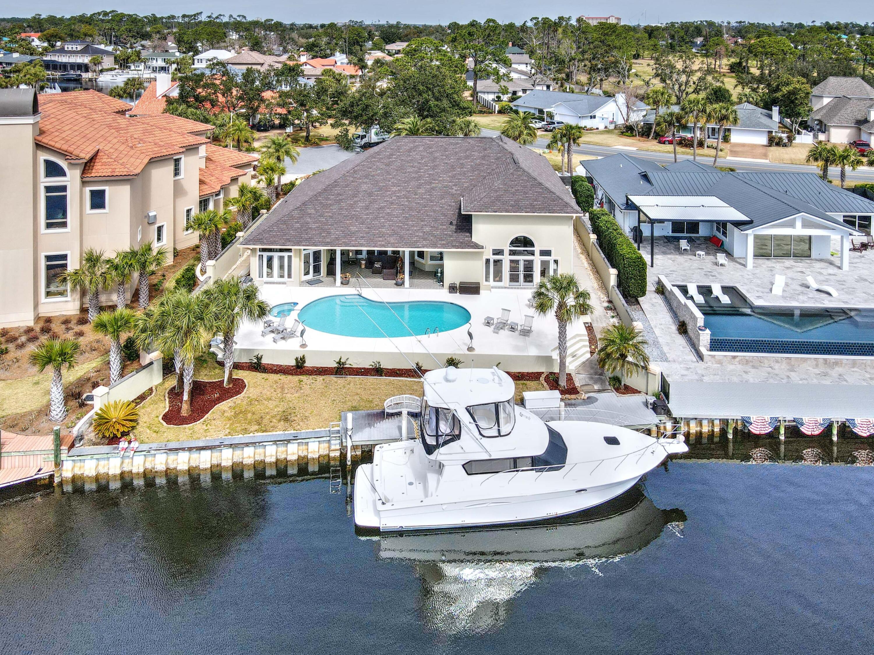 Waterfront home in Bay Point, east of the bridge and 90 feet on DEEP WATER - perfect for your yacht & water toys! Relax and take in gorgeous Grand Lagoon views from your spacious covered patio, pool, and hot tub. Featuring 4 bedrooms and 4 baths, enjoy the perfect floor plan with almost all rooms on the main level, including the master bedroom and office. Open kitchen, butler's pantry, tall ceilings, ample storage, and a view from every room! Great curb appeal, 3 car garage, new roof, 3 HVAC systems , new hot water heater, a second instant gas hot water heater for the master, pool just resurfaced, updated kitchen and brand new master bath. Call today - this literally checks all the boxes of waterfront simple elegance - for your new home in Panama City Beach Florida!