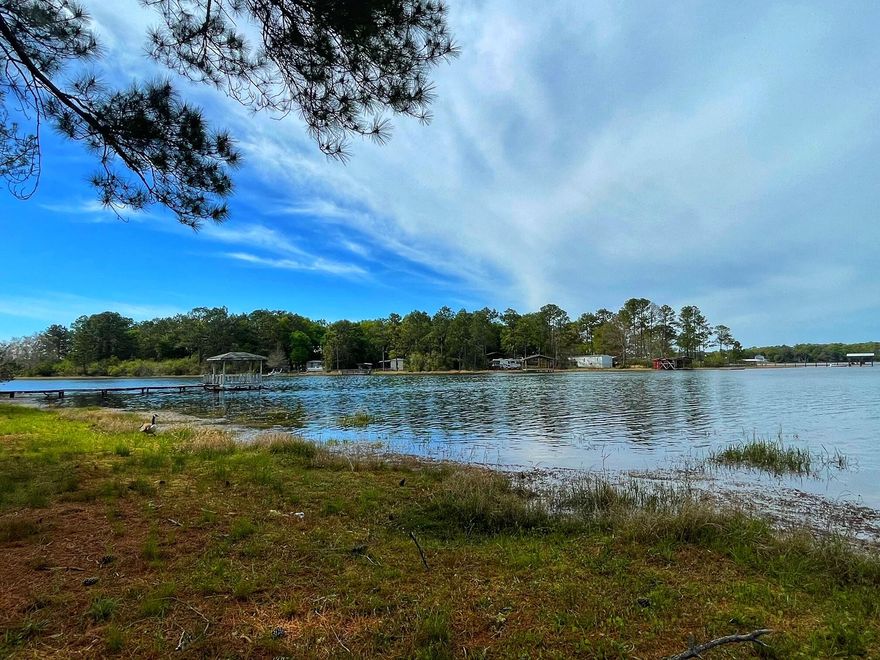 Beautiful waterfront lot (almost 1 acre). 200 feet of expansive, waterfront views!  This lot has 2 'tiny' homes that are just waiting for the new buyers to finish them out. The homes are both deemed safe for winds reaching 150 mph as per the manufacturer. In addition to the tiny homes, the seller has 2 new storage buildings/workshops on the property. All utilities are on the property to include- water, septic and electric. Juniper lake is a state managed lake and is known for it's record bass and bream. Come check it before it's gone! All measurements must be verified by buyer.