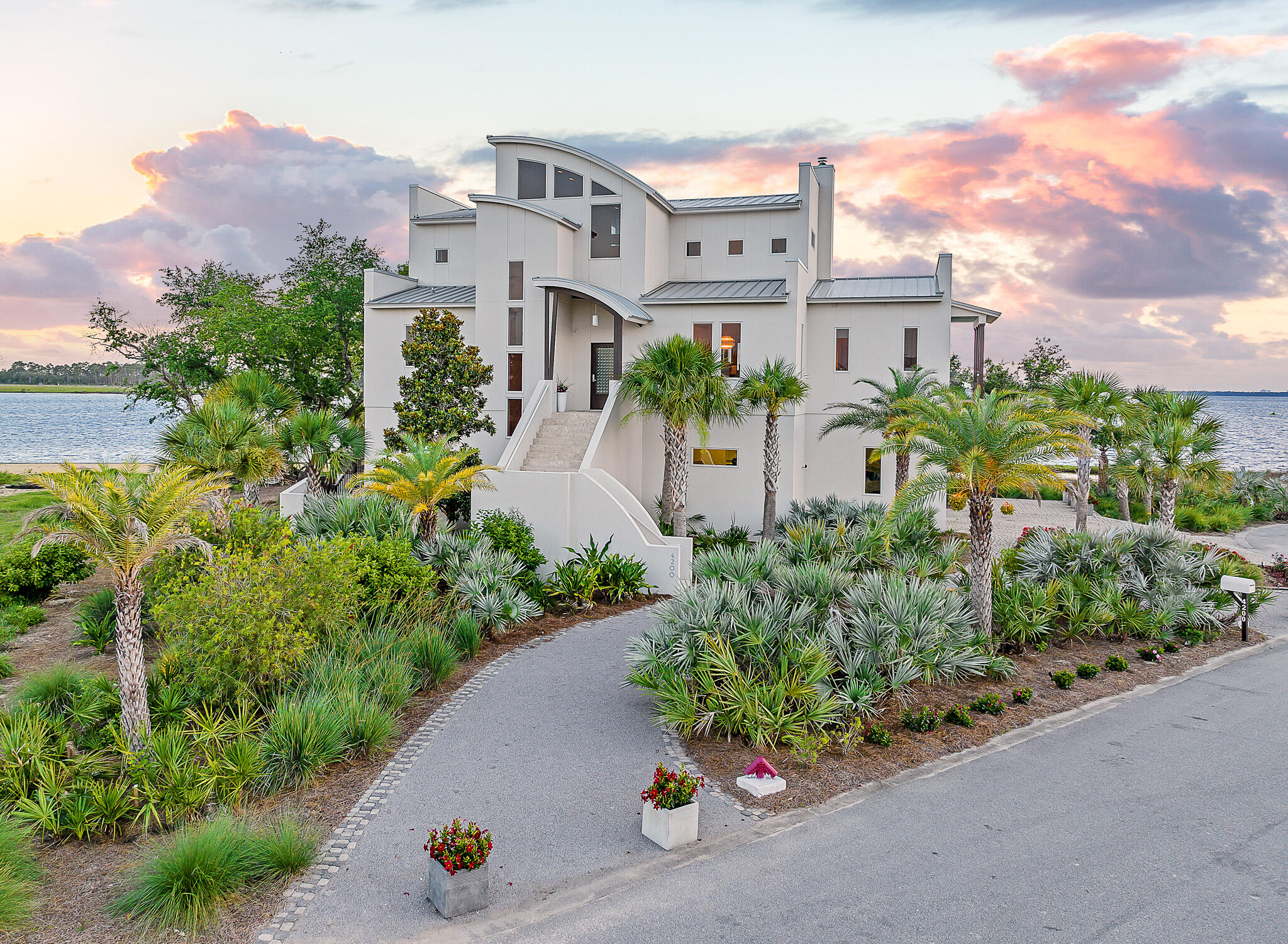 Nestled on the shores of North Bay, on a private island just off the coast in northwest Florida, sits a truly quiet and peaceful oasis of natural tropical beauty and a home of remarkable contemporary and modern architecture. This soaring three story estate was masterfully designed and brought to life by renowned Architect J Michael Hunnicutt and built by Rita Jones Construction. Spanning three levels with over 5,000 square feet, every room provides incredible waterfront views and offers expansive outdoor living with bay view covered porches on each level.