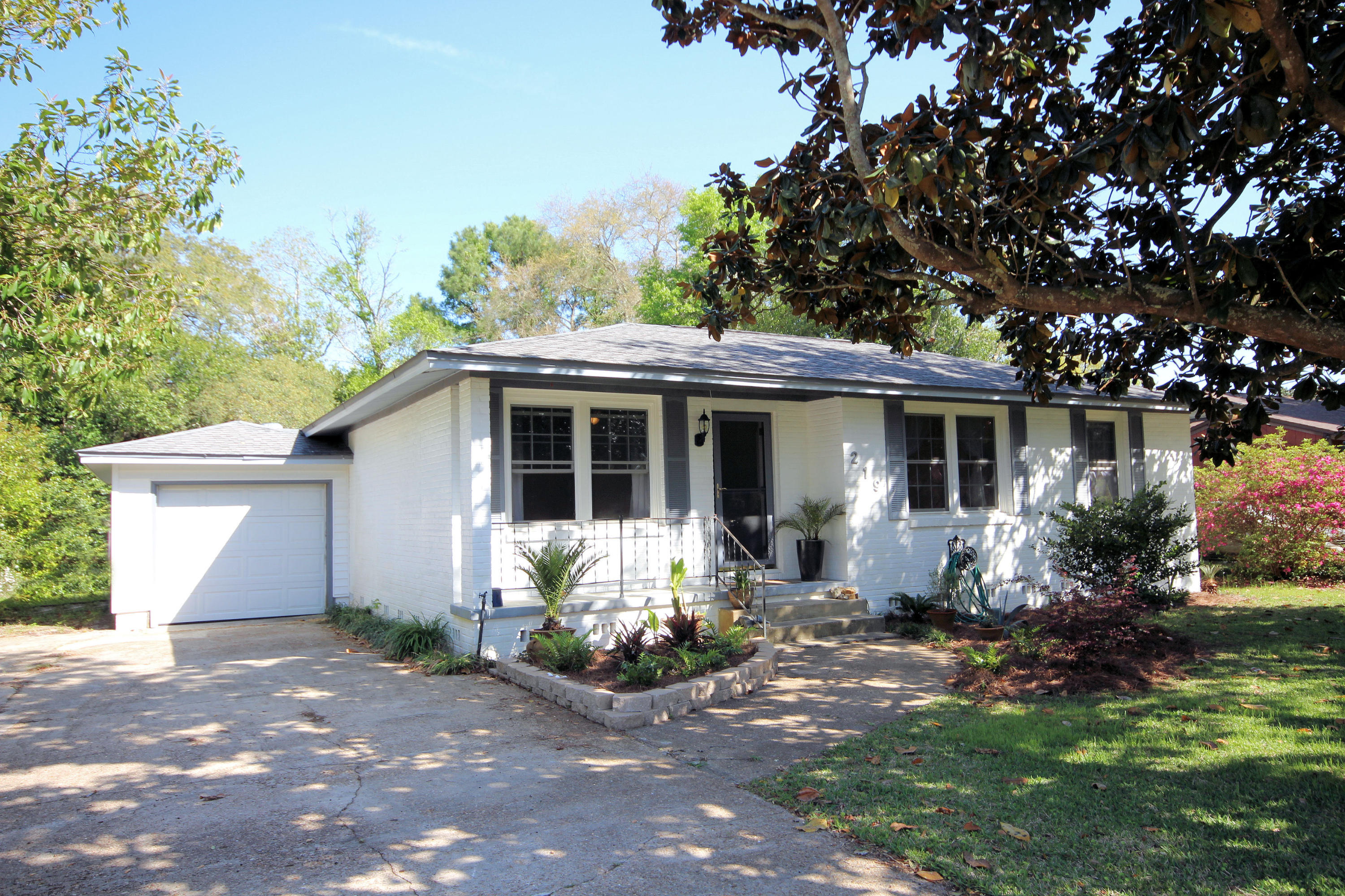 Located one block from Garnier Beach Park, ''Old Florida'' meets updated style in this classic white painted brick home. Curb appeal! Covered front porch and leaded glass door. Refinished original wood floors in living room, hallway and bedrooms along with freshly painted walls, and vinyl double pane windows (bedrooms, master bath and living room) add beauty. Kitchen features oak cabinets and plenty of counter space. Central dining area opens to living room as well as kitchen and stairs with tiled risers lead down to a large 22' X 17' family room. Newer fans in master and guest bedroom, living room, family room and kitchen add energy efficiency and a modern flare. Family room back door opens to a large fenced back yard with an oversize deck and yard building. Attached garage is 24X11.