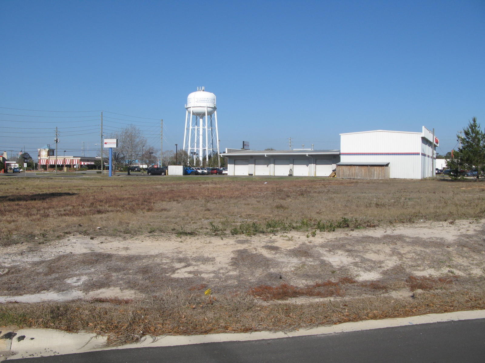 Cleared corner lot, mostly level with slight slope. Fronts on 3 streets, adjoins Post office property. Has billboard. Had development order to be able to build 18,375 sqft of retail and 16,200 sqft of office/warehouse.