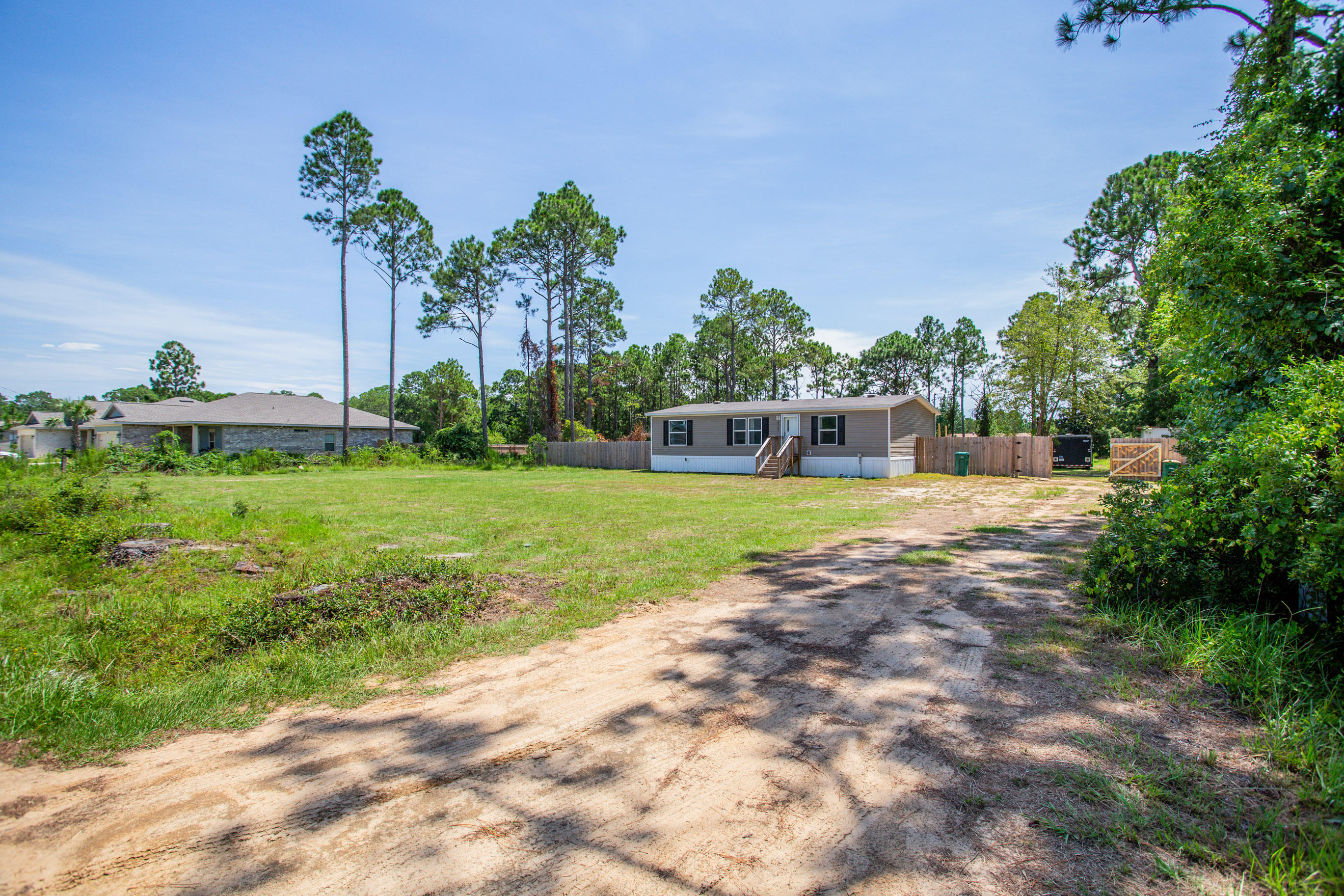Don't miss out on this opportunity to purchase a large parcel in East Navarre, in a developing area, seconds from the beach. This over an acre of property consists of a pristinely kept, newer 3/2 home (2018) & large outdoor workshop with power! Inside, the light & bright interior boasts a spacious open concept living space. Kitchen comes complete with matching Frigidair appliances and a view from the kitchen sink overlooking the backyard. Split floor plan design with a walk-in closet in all bedrooms for ample amounts of storage space. Outside, enjoy entertaining from the large deck overlooking the expansive, cleared yard. Double-gate on the side opens wide enough to pull in all of your vehicles or trailers near the workshop. Schedule your showing today! Buyer to verify all details.