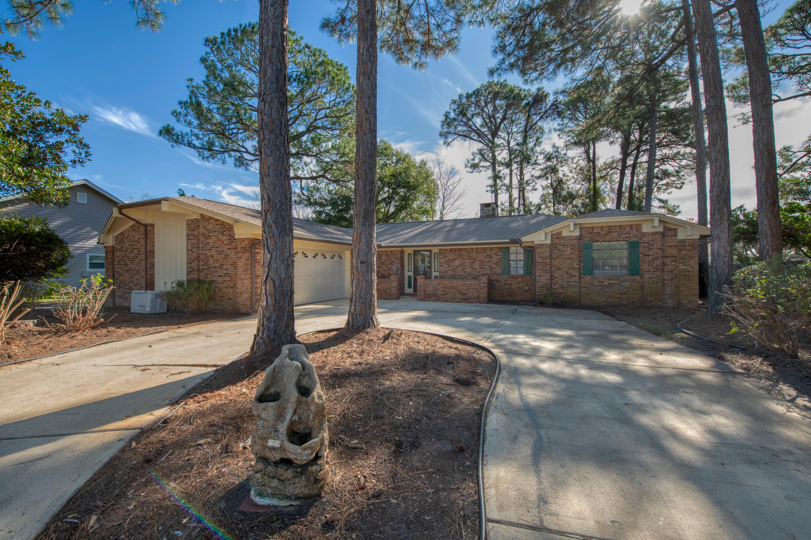 Come see this lovely 2 bedroom, 2 bathroom brick home in one of the most desirable neighborhoods in Destin. Located across from the popular Indian Bayou Golf Course. Features a circular driveway in a quaint setting. Inside, you will find an Open floor plan with high ceilings. The focal point of the family room is a raised hearth wood burning fireplace with built in bookcases on each side. The kitchen has a large pantry and even a trash compactor. From the great room, there is a screened porch overlooking wooded area which makes for a very quiet and private setting. The backyard is fenced in. The Master bedroom and bath are quite large. There is a big walk-in closet in the Master. There are 2 water heaters and one new Emergency generator. The furniture was left for staging but is