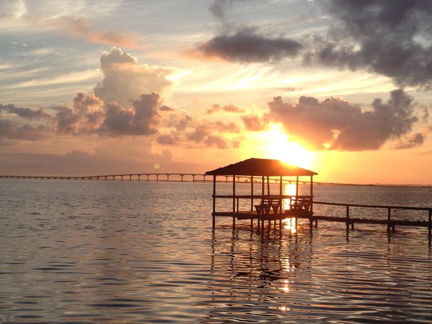 Featured in HGTV magazine in 2013, this big open water  bay front property features 126ft of water frontage a large dock with boat house. The main house (1674) consist of three large bedrooms, three full baths, large living space with vaulted ceilings, windows galore that highlight  the amazing a bay views, large dock and recently fortified seawall and rip rap. The back house (1676) features a large 1000 sq ft guest apt currently rented for $2000 a month, the lower level of the bak house features a large office space with two work bays and a powder room heated and cooled as well as 3 large storage areas. For a small business owner this owner  this property is a one of a kind opportunity. Sold furnished, property grossed $91,000 in long term rental income for both homes combined.