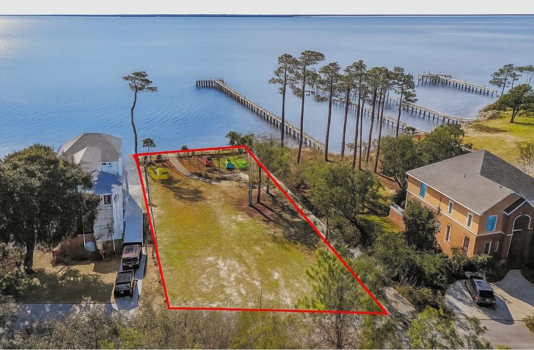 A MUST SEE!!! GO CHECK OUT THIS BEAUTIFUL LOT! One-of-a-Kind Lot in Magnolia Harbor - Ready to Build! Prepare to be amazed! Nestled in the highly sought-after deeded waterfront community of Magnolia Harbor in Navarre, this incredible lot is anything but ordinary. Fully cleared, beautifully landscaped, and ready for you to bring your dream home to life, it's the perfect canvas for your vision. Unique features include a 5-hole golf putting green, a cozy fire pit, and a charming creek walk-over bridge, making this property truly stand out. You will enjoy breathtaking sunsets, cool Gulf breezes, and the serene lifestyle this property offers every single day. Located just minutes from A+ schools, neighborhood Walmart, shopping, dining, Hurlburt Field Air Base, and the iconic sugary white sands of Navarre Beach, this lot combines convenience with tranquility. This is more than a lot it's the foundation for your future. Don't miss this opportunity to own something truly special.