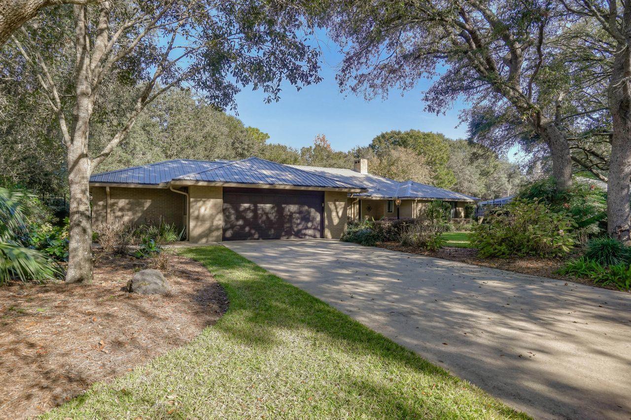 Amazing Rocky Bayou Country Club golf course AND secluded brick home. This beauty is situated on 1/2 acre of private, custom designed and maintained park like grounds. The 3 bedroom, 3 full bath home is open, crisp and clean with a great split bedroom plan and vaulted ceiling with warm remote controlled gas fireplace. So many custom upgrades to include Bosch stainless steel appliances, beautiful granite in the kitchen, High end metal roof installed in 2018, custom gates and wrought iron fence, extra large garage with workshop and covered parking for toys. Amazing electronic blinds, recessed lighting, upgraded hurricane shutters, bonus Florida room plus another Florida room not included in square footage. This home is a must see!!!
