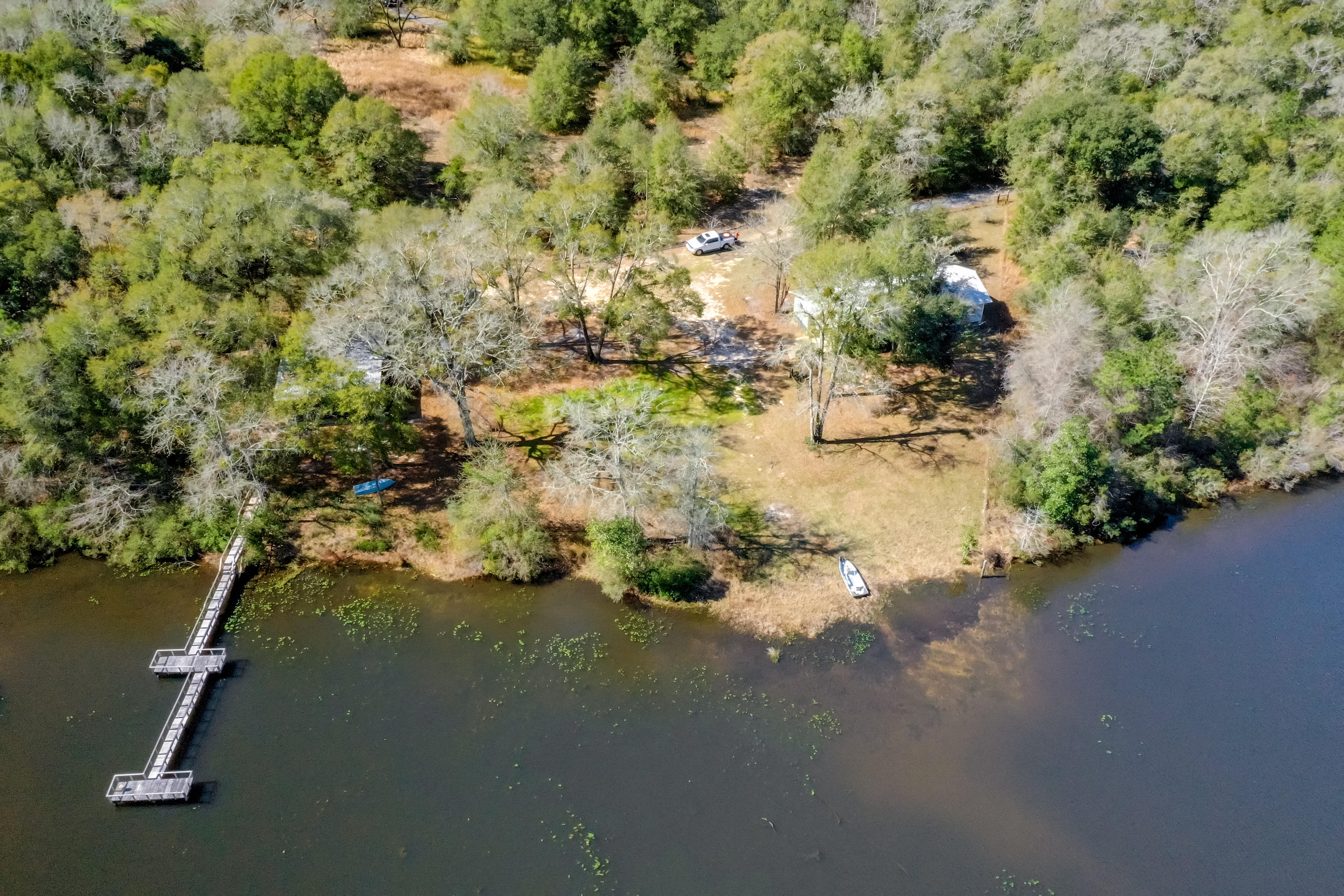 Your retreat awaits! 48 Acres with a private 5+ Acre Lake + access to Pond Creek! New Dock in 2020, 2 Homes, Storage Building, and Workshop. Get out ''un plug'' and enjoy nature on the weekends or full time! Cabin features a fireplace in the Living Room, Florida room, 2 bedrooms, 1 bathroom, and fully equipped kitchen. Room sizes are for the Cabin. 2nd home is a 1990 single wide Mobile Home with 2 bedrooms, 1 bathroom, plus attached Florida Room & Carport. Workshop is located next to the cabin, plus 2 detached carports: a 1-Car and a 2-Car. Bring your recreational vehicles to roam the land, plus a trail around the lake to the backside of the property that adjoins Turkey Track Rd and Pond Creek. Schedule your private viewing today! Additional Feature Sheet in Documents Section.