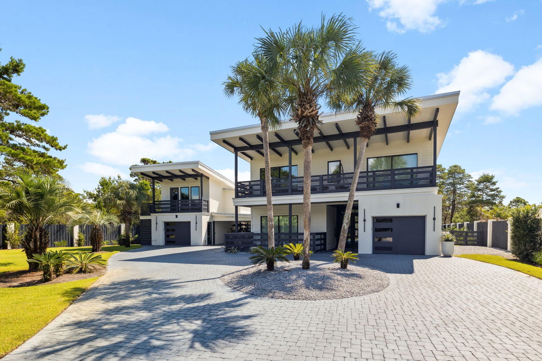 Welcome to an entertainer's dream home on a half-acre in The Pines of Blue Mountain Beach off Scenic Hwy 30A .This stunning contemporary home offers a true ''wow'' factor from the moment you arrive through the gated entrance. You'll be delighted by the open floor plan, where the kitchen, dining, and living areas seamlessly flow together, all featuring vaulted beamed ceilings, white oak floors, and unique lighting. A wall of sliding glass windows leads to a screened porch with oversized lounging and dining arrangements. Just steps away, the outdoor entertaining space awaits with an outdoor kitchen and covered pavilion with lounge seating, television, a circular dining table and ping pong! Delight under the stars by the outdoor fireplace, with cozy chairs. Children will love bouncing on the in ground trampoline or spending time in the the two-story playhouse, which can also easily serve as a yoga/art studio or office space. Enjoy the generously oversized heated saltwater pool with an attached spa and sun shelf. The gourmet kitchen boasts high-end Thermador appliances, two dishwashers, a 6-burner convection dual-fuel range, and a nugget ice maker in the pantry. The first-floor primary suite offers simple elegance with a private covered porch and firepit lounging. The second level includes a junior suite with a balcony, an extra-large shower, and a walk-in closet, along with two guest bedrooms each with a private bath. Separate living quarters are located above the second garage, providing additional space for guests with a full kitchen, living area, bedroom, and shower bath. The location is ideal, with Gulf Place just a 5-minute drive or a 10-minute bike ride away, providing access to numerous shops, restaurants, and the Ed Walline beach access. You can also easily reach Seaside via the bike path or Grand Boulevard with a quick 20-minute drive and Blue Mountain Beach within 2 minutes. This property offers versatility as a full-time residence, a vacation home, or an income-producing investment.