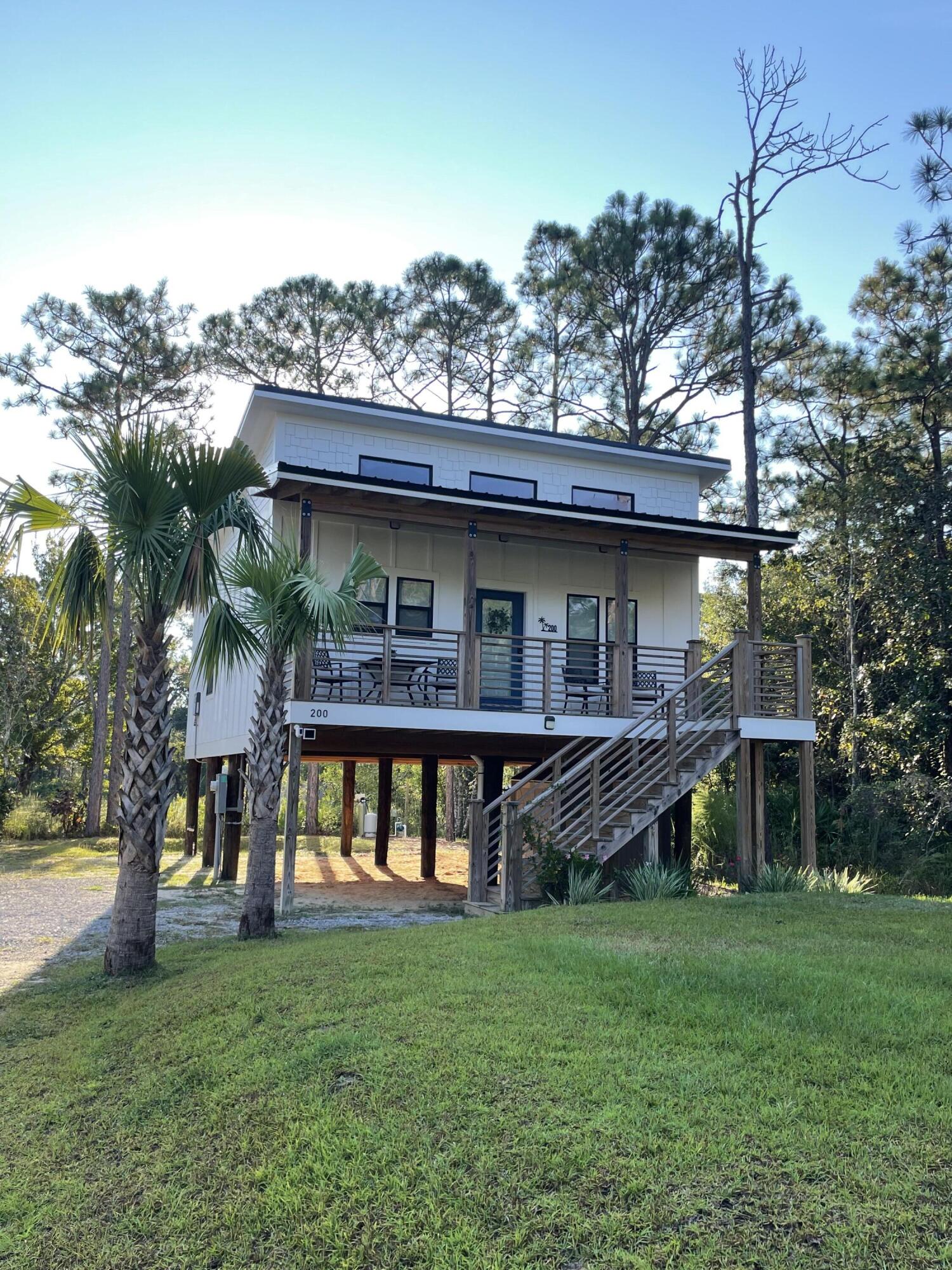 Charming Coastal Cottage in Santa Rosa Beach - Fully Furnished & Ready to Enjoy! Welcome to your perfect getaway! This turn-key, fully furnished 2-bedroom, 2-bathroom cottage is a dream come true for coastal living enthusiasts or savvy investors. Located just 3 miles from Ed Walline Beach, this 2021-built home blends modern amenities with timeless charm, making it ideal for relaxation and short-term rental opportunities. Built to last with a durable metal roof, hardy board siding, and impeccable craftsmanship, this home features soaring 13-ft ceilings with dark walnut beams that set the tone for a spacious and stylish living area. The cozy interior includes a couch, accent rug, accent table, lamp, and a custom ''Blue Palm'' metal wall sign. The gourmet kitchen is fully stocked with dinnerware, flatware, cookware, and modern appliances, complete with butcher block counters, black bar stools, and a farmhouse sink for a touch of rustic elegance. The primary suite offers a king bed, nightstands, and serene decor, while the guest room provides a queen bed and equally cozy charm. Outdoors, you'll find an inviting oasis with string lights, hammock chairs, a ring toss game, and a spacious deck with patio furniture, perfect for al fresco dining. A shed keeps your beach supplies organized. Additional highlights include a tankless water heater, luxury LVP flooring, shiplap accent walls, and a stackable washer/dryer for convenience. This property is already an active Airbnb listing, offering a seamless entry into the desirable 30A rental market. Don't miss your chance to own this slice of paradise in the heart of Santa Rosa Beach!