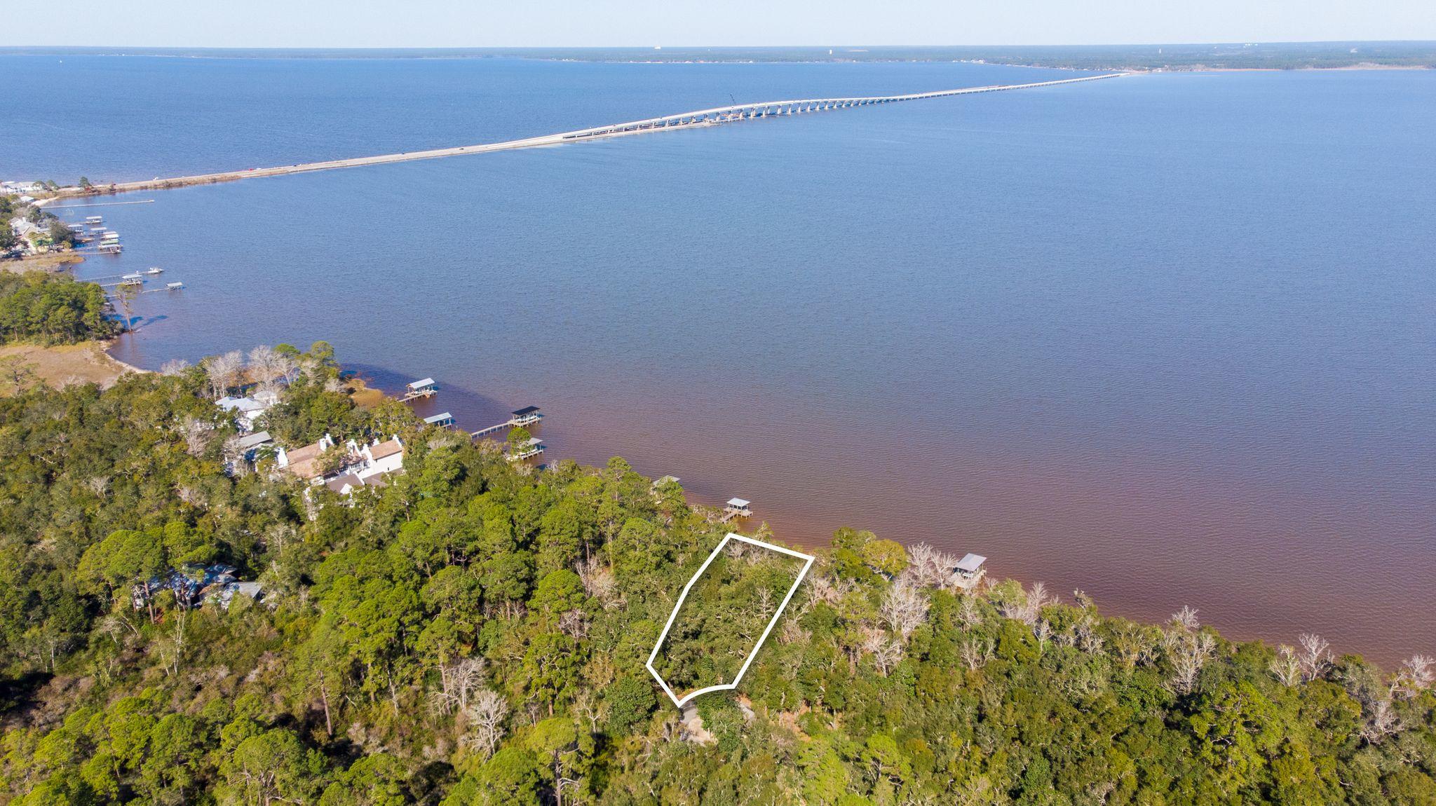 Take a drive through an exclusive untouched part of Point Washington State Park to see the quiet and serene views from the only available bay-front lot in The Estuary. This over-sized homesite offers over 100feet of waterfront and generous views from the Choctawhatchee Bay. With plenty of privacy from the natural vegetation and towering pines, you and your family enjoy direct access to the Bay. Highway 30A and the Gulf's emerald ocean with white sands are only miles away from this private oasis. The Estuary is a secluded, gated community that showcases old oak, and magnificent magnolia trees that paint the ceiling for this 39 lot neighborhood. The lot has a full set of approved plans competed by Geoff Chick that can be purchased separately. Flood Zone: X