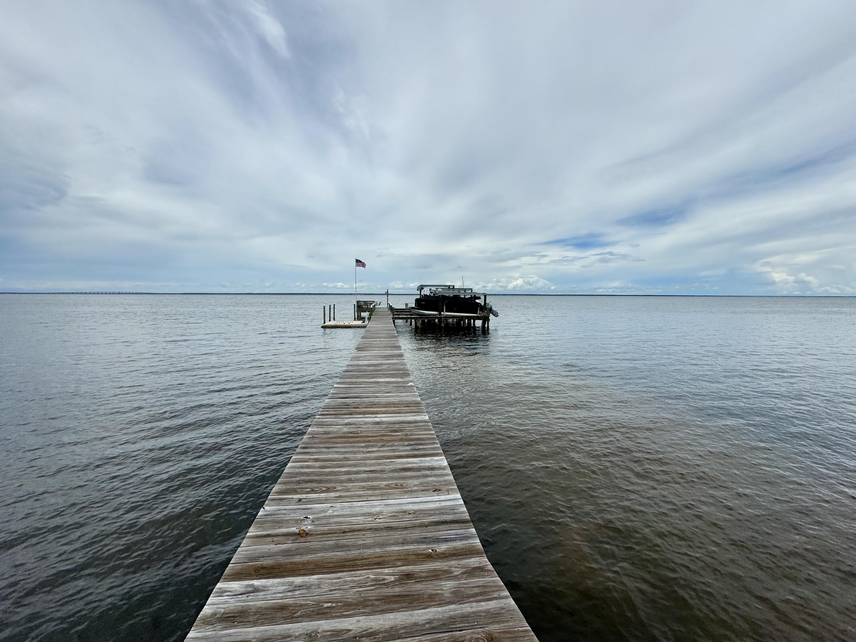 Waterfront Community with Boat Dock & private Boat Slip come with this unique 8 Lot Community!! Beautiful house plans already drawn up with Bay views from your second floor! Lot is cleared, filled, High & Dry and in an 'X' Flood Zone! Beautiful Magnolias and Oak trees adorn the lot and provide privacy. Dolphin watch, fish, paddleboard or just sun on your shared dock! You'll love the Waterfront lifestyle without the Waterfront price! Just 5 minutes to our gorgeous white sand beaches, beach bars, eateries yet removed and serene.