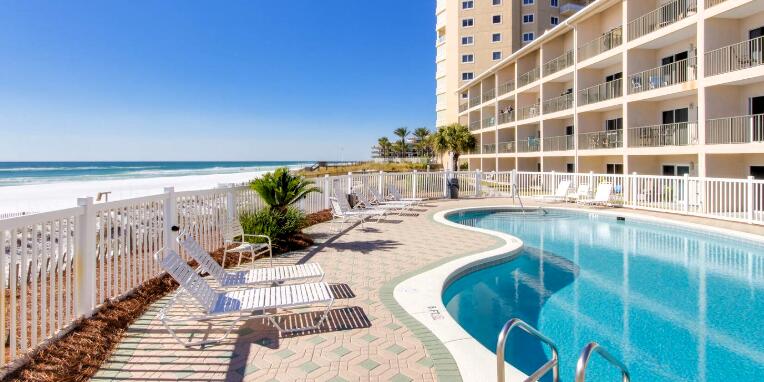 Stunning First Floor oasis. Don't miss this brand new beachfront condo with 2 full bathrooms. This completely renovated condo is a perfect getaway, having undergone a full transformation in 2024. Designed to sleep up to eight people, the unit features a custom King bed with two floating twin beds, along with Full over Full hallway bunks--ideal for families or groups looking for comfort and style. The first-floor location allows for easy access with no elevators or stairs to navigate. Simply walk right in and step outside to your private patio, offering direct views of the pool and the pristine, emerald waters of the Gulf of Mexico. The beach is literally your backyard and playground! Prime location directly across the street from the Silver Sands Outlet Mall, Chick-fil-A and Windixie.