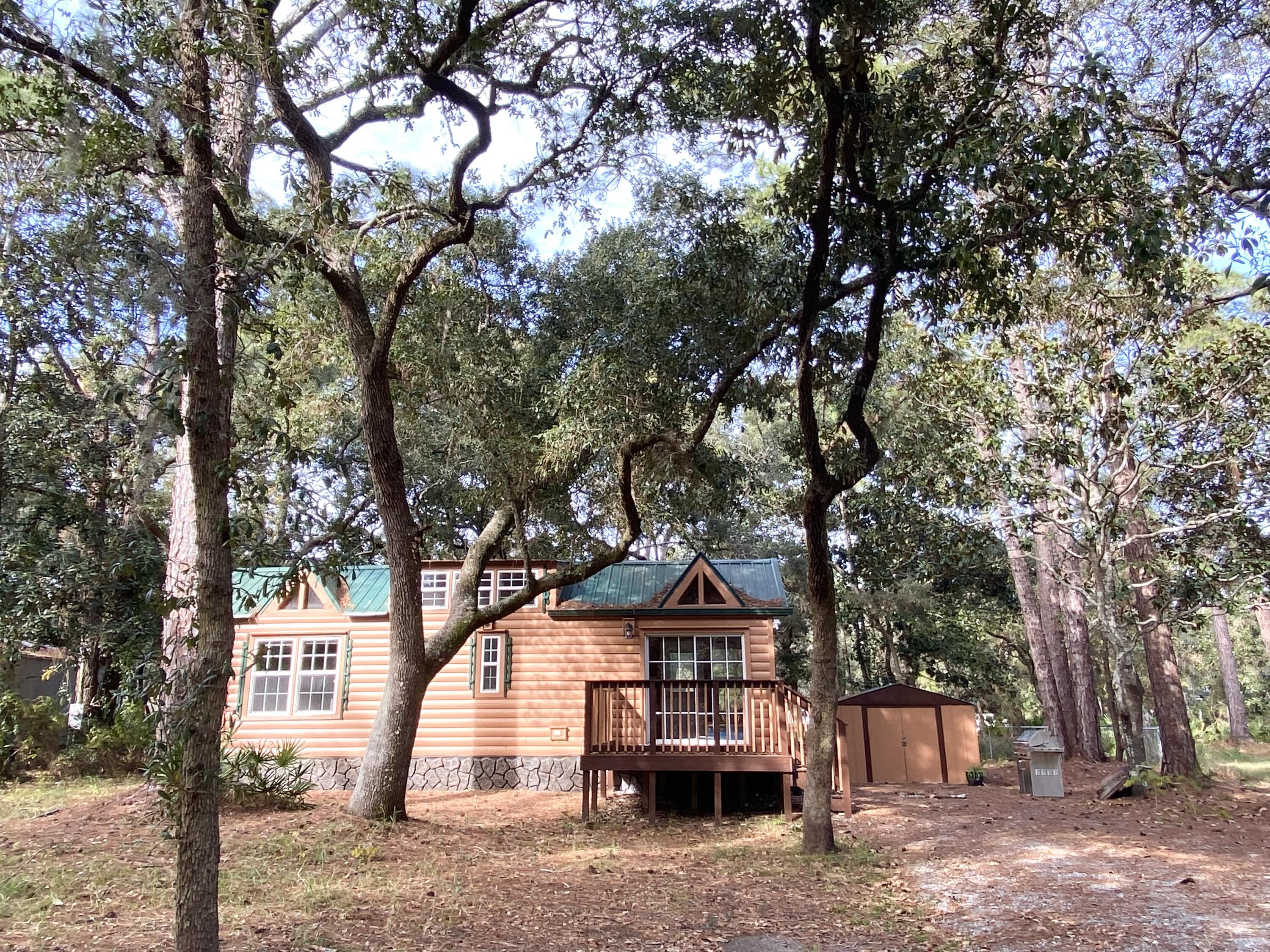 A gem with so many possibilities! Option to have your dream tiny home in the heart of Santa Rosa Beach, a great investment opportunity, or to find the perfect lot with old growth oak and pine trees. This .23 acre lot is located just 2 blocks from Choctawhatchee Bay, and moments from the white sand beaches of Walton county, nature trails, Topsail State Park, and all the restaurants and shops of Grand Boulevard. The 12 x 35 adorable cedar planked tiny home actually has lots of space, with a living area, kitchen, full bath, bedroom, and bonus loft. Location of this beautiful property is amazing. Come see this for yourself to find your own wonderful slice of beach life!