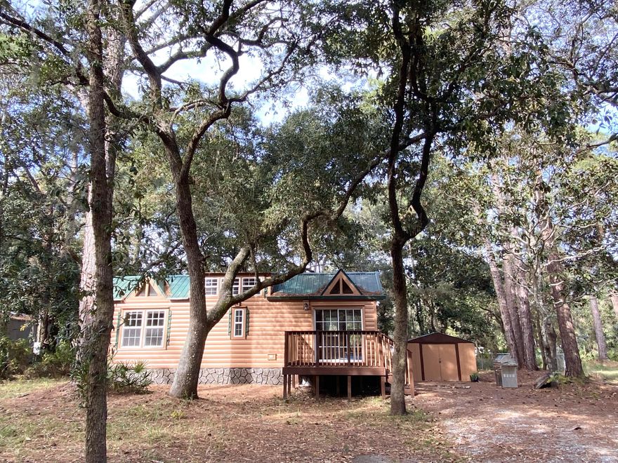 A gem with so many possibilities! Option to have your dream tiny home in the heart of Santa Rosa Beach, a great investment opportunity, or to find the perfect lot with old growth oak and pine trees. This .23 acre lot is located just 2 blocks from Choctawhatchee Bay, and moments from the white sand beaches of Walton county, nature trails, Topsail State Park, and all the restaurants and shops of Grand Boulevard. The 12 x 35 adorable cedar planked tiny home actually has lots of space, with a living area, kitchen, full bath, bedroom, and bonus loft. Location of this beautiful property is amazing. Come see this for yourself to find your own wonderful slice of beach life!