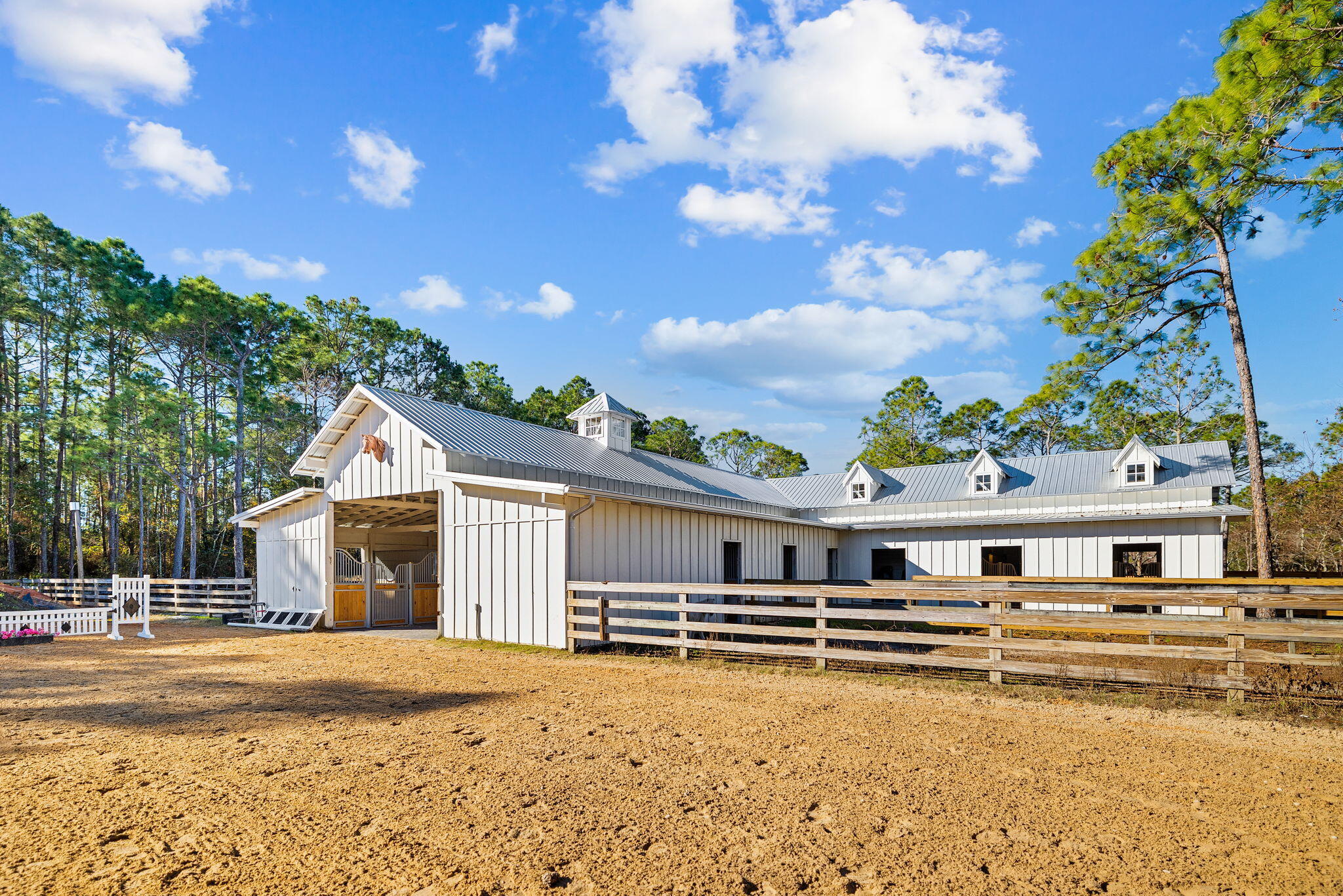 EXQUISITE EQUESTRIAN ESTATE primely located just 4.3 miles from the sugar white beaches of 30A on Florida's Emerald Coast. This stunning 3-bedroom, 2-bath coastal farm cottage with over 1900 square feet welcomes guests with thoughtful details including shiplap cathedral ceilings, modern lighting, Calacatta quartz countertops, cafe appliances, engineered wide plank hardwood floors, a clawfoot tub, and innumerable fine touches. The open floor plan is accentuated with a pristine cafe kitchen featuring modern, upscale white appliances and cabinetry with unlacquered brass hardware, custom vent hood, designer light fixtures, large island with extra seating, and breakfast banquette. Natural lighting enhances the cool color palette that flows continuously from this space through the living and