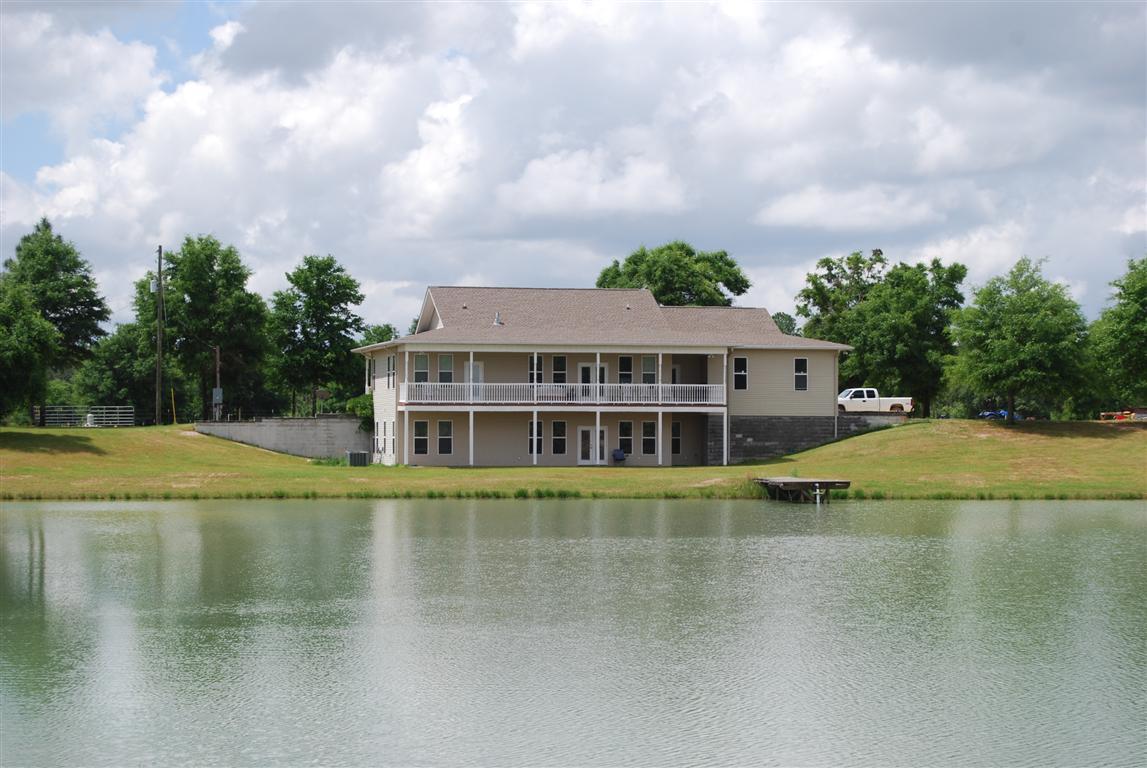 COUNTRY LIVING WITH A PLACE FOR YOUR HORSES!Custom built 4 bedroom home with 3577 sq.ft., 2 fireplaces, Open floorplan, large kitchen with center island, two covered porches overlooking the lake and a large covered front porch for relaxing, 2.5 baths, Hardwood floors throughout, a separate barn/workshop/tack room, stables, riding area, covered storage, Spring fed Lake with a dock and 36.5 acres for $600,000