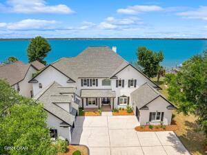 Discover the epitome of waterfront elegance in this luxurious two-story residence nestled within the prestigious Panama Country Club in Lynn Haven, Florida. Boasting an impressive 5,502 square feet of meticulously designed living space, this exquisite home offers a seamless blend of sophistication and relaxation. From the moment you arrive, you'll be captivated by the stunning panoramic views of the water, setting the stage for a lifestyle of unparalleled luxury. Indulge in the ultimate waterfront experience with your very own private deep water dock featuring a convenient boat lift, allowing for effortless access to serene waters of St. Andrews Bay and direct Gulf of Mexico access. After a day of boating and exploration, retreat to your own personal oasis and unwind in the inground spa
