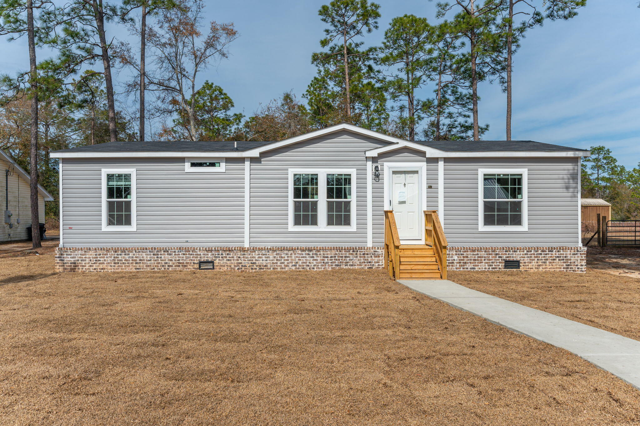 This is not your standard manufactured home. Spacious and modern 1,248 sq. ft., featuring 3 bedrooms and 2 bathrooms with an open concept floor plan. The home offers a split bedroom layout, ensuring privacy, with the master suite boasting a large walk-in shower & a double sink vanity. Off the master bathroom you will find a large walk-in closet. The open kitchen, dining, and living areas create a bright and inviting space, perfect for both relaxing and entertaining. The kitchen features stainless steel appliances and beautiful shaker style cabinets. The Master Suite has a large standing shower with double vanity & a walk-in closet with plenty of space! This home comes with finished drywall and vinyl flooring throughout. The exterior has upgraded brick in place of the skirting almost all the way around, as well as a concrete parking pad for additional convenience. It is located a short distance of less than a ?? mile to Kings Lake which is approximately 347 acres in size and what we know as one of the best fishing lakes in the area. City Limits of DeFuniak Springs is approximately 6-7 miles from this property. Enjoy the small town feel while still being only about a 45-minute drive to the white sandy beaches on the Gulf Coast or one of the multiple natural springs to the East of us, in Ponce De Leon. This place is ready for its first live-in home owner!!!!