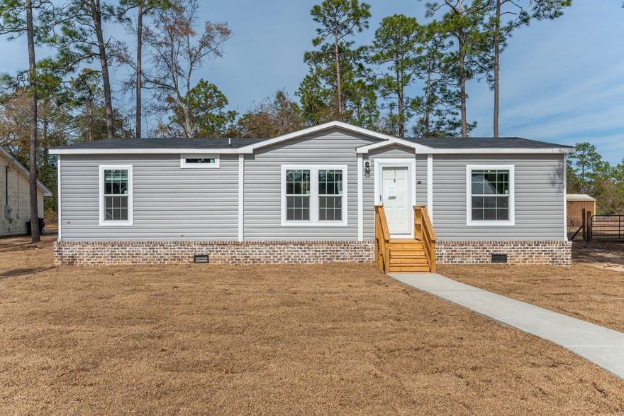This is not your standard manufactured home. Spacious and modern 1,248 sq. ft., featuring 3 bedrooms and 2 bathrooms with an open concept floor plan. The home offers a split bedroom layout, ensuring privacy, with the master suite boasting a large walk-in shower & a double sink vanity. Off the master bathroom you will find a large walk-in closet. The open kitchen, dining, and living areas create a bright and inviting space, perfect for both relaxing and entertaining. The kitchen features stainless steel appliances and beautiful shaker style cabinets. The Master Suite has a large standing shower with double vanity & a walk-in closet with plenty of space! This home comes with finished drywall and vinyl flooring throughout. The exterior has upgraded brick in place of the skirting almost all the way around, as well as a concrete parking pad for additional convenience. It is located a short distance of less than a ?? mile to Kings Lake which is approximately 347 acres in size and what we know as one of the best fishing lakes in the area. City Limits of DeFuniak Springs is approximately 6-7 miles from this property. Enjoy the small town feel while still being only about a 45-minute drive to the white sandy beaches on the Gulf Coast or one of the multiple natural springs to the East of us, in Ponce De Leon. This place is ready for its first live-in home owner!!!!