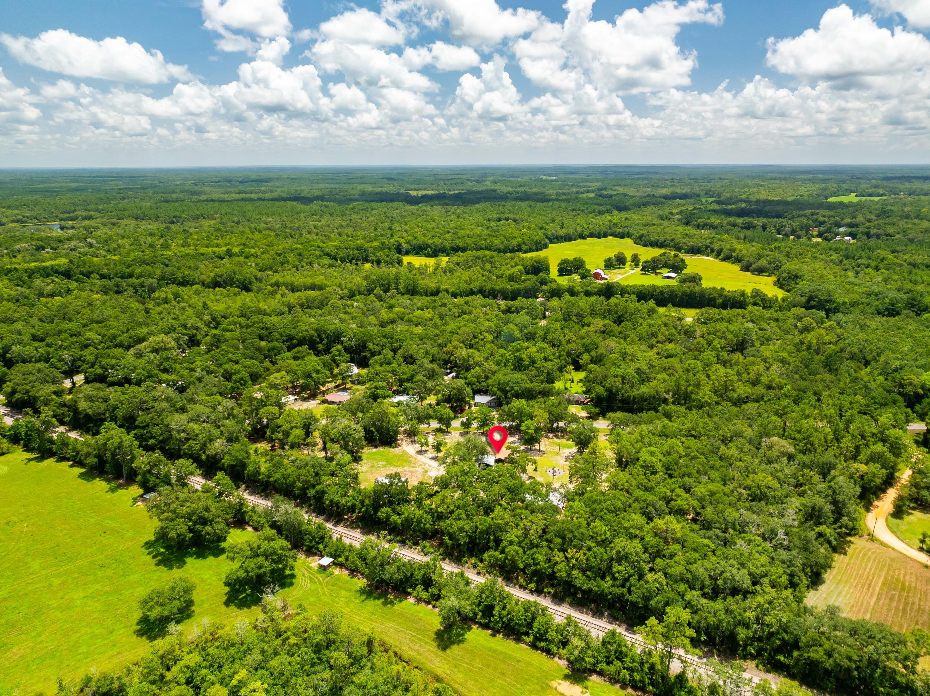 Country living with modern comfort! Unlock the full potential of this unique investment opportunity; perfectly positioned between three of Northwest Florida's most beloved freshwater destinations: Vortex Springs, Ponce de Leon Springs, and Morrison Springs! Discover the perfect blend of rural charm and contemporary upgrades at this beautifully maintained 4-bedroom, single story home, on 5 sprawling acres. Featuring an additional campsite, and possible studio in the back, this property offers the serene country lifestyle with quick access to I‑10. The split floor plan offers privacy with the primary suite on one side and three additional bedrooms on the other. The kitchen features custom wood cabinetry and a convenient breakfast bar, perfect for casual dining or entertaining. Need room for hobbies, tools, or equipment? You'll love the 50' x 32' powered workshop, ideal for cars, boats, storage, etc. There's also a 36' x 16' powered pole barn and a 24' x 24' carport-style pole barn, offering even more versatility for outdoor storage or workspace. This property delivers a unique opportunity: a turnkey, move in-ready home, plus a workshop and barns on acreage, all set within a vibrant Panhandle community rich in natural beauty. Whether you're looking to generate short-term rental income, expand a multi-use property portfolio, or create your own nature-based retreat, this property delivers BIG value and versatility.