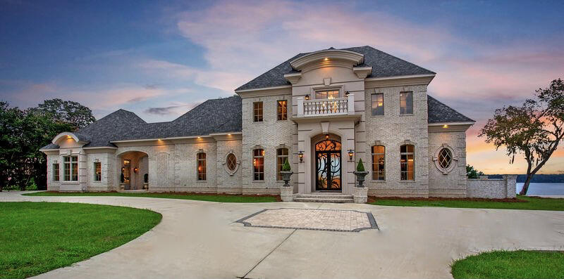 ''Simply Perfect'' is what you will say when you are welcomed through the massive artisan iron double doors. This custom home was architecturally designed & built like no other on Lake Eufaula. Expansive elevated views of the lake are enjoyed in all the living & bedroom suites of the home. This Interior Designer's personal home is luxurious throughout, beginning in the 2-story foyer with custom wrought iron floating staircase, custom trim, & marbleized Italian porcelain flooring that takes you into an open living room with a fireplace, dining room and gourmet kitchen, and a panoramic view of the Lake. The folding ''Nana Wall'' glass doors open to expand the living room onto the large back porch with outside living and dining areas, featuring an in-grade hot tub spa/pool with a reverse reverse edge overlooking the Lake. The expansive covered porch has 3 ceiling fans and massive stone gas log fireplaces on either end, with 14' tongue and groove cypress ceilings inside large brick archways. The center of the porch features an outdoor kitchen and dining area. The downstairs features 14' ceilings with custom millwork trim and decorative ceilings throughout. The main level is perfect for entertaining large or small groups, both inside and out with many gathering areas for family and friends. An open Chef's Kitchen has accents of stone throughout. A 10' island in the center of the kitchen provides extra seating for guests. Adjacent to the main kitchen is a scullery kitchen along with a butler's pantry containing a double oven, wine refrigerator, freezer with ice maker, wine cabinet and bar sink. The Dining Room has a round intersecting ceiling accented by an artistic contemporary chandelier. The main floor Master Suite consists of 4 rooms. The Master Bedroom has a decorative ceiling and offers tremendous views, especially at sunrise and sunset on the Lake. The Master Closet is a large room with an island cabinet and quartzite top, surrounded by mirrored and frosted glass closet doors with deep drawers below. The enclosed closets around the perimeter and dedicated shoe racks are illuminated by soft indirect LED lighting. An enclosed washer/dryer closet completes the room. The Master Bath is luxurious with style from ceiling to floor. A quartzite and glass column centerpiece with artistic chandelier creates a wall feature which separates the large soaking tub from the walk-through shower with 3 heads and hand held unit. A Wet Closet with European style decor completes the Master Suite. The Executive Office near the breezeway and porch with cathedral ceiling is a retreat in itself, with rich colors and dramatic ceiling accents and French doors opening onto an additional porch living area with a dramatic 24' cathedral ceiling with a tall stone fireplace and chimney. COME AND SEE!
