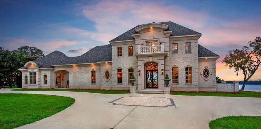 ''Simply Perfect'' is what you will say when you are welcomed through the massive artisan iron double doors. This custom home was architecturally designed & built like no other on Lake Eufaula. Expansive elevated views of the lake are enjoyed in all the living & bedroom suites of the home. This Interior Designer's personal home is luxurious throughout, beginning in the 2-story foyer with custom wrought iron floating staircase, custom trim, & marbleized Italian porcelain flooring that takes you into an open living room with a fireplace, dining room and gourmet kitchen, and a panoramic view of the Lake. The folding ''Nana Wall'' glass doors open to expand the living room onto the large back porch with outside living and dining areas, featuring an in-grade hot tub spa/pool with a reverse reverse edge overlooking the Lake. The expansive covered porch has 3 ceiling fans and massive stone gas log fireplaces on either end, with 14' tongue and groove cypress ceilings inside large brick archways. The center of the porch features an outdoor kitchen and dining area. The downstairs features 14' ceilings with custom millwork trim and decorative ceilings throughout. The main level is perfect for entertaining large or small groups, both inside and out with many gathering areas for family and friends. An open Chef's Kitchen has accents of stone throughout. A 10' island in the center of the kitchen provides extra seating for guests. Adjacent to the main kitchen is a scullery kitchen along with a butler's pantry containing a double oven, wine refrigerator, freezer with ice maker, wine cabinet and bar sink. The Dining Room has a round intersecting ceiling accented by an artistic contemporary chandelier. The main floor Master Suite consists of 4 rooms. The Master Bedroom has a decorative ceiling and offers tremendous views, especially at sunrise and sunset on the Lake. The Master Closet is a large room with an island cabinet and quartzite top, surrounded by mirrored and frosted glass closet doors with deep drawers below. The enclosed closets around the perimeter and dedicated shoe racks are illuminated by soft indirect LED lighting. An enclosed washer/dryer closet completes the room. The Master Bath is luxurious with style from ceiling to floor. A quartzite and glass column centerpiece with artistic chandelier creates a wall feature which separates the large soaking tub from the walk-through shower with 3 heads and hand held unit. A Wet Closet with European style decor completes the Master Suite. The Executive Office near the breezeway and porch with cathedral ceiling is a retreat in itself, with rich colors and dramatic ceiling accents and French doors opening onto an additional porch living area with a dramatic 24' cathedral ceiling with a tall stone fireplace and chimney. COME AND SEE!