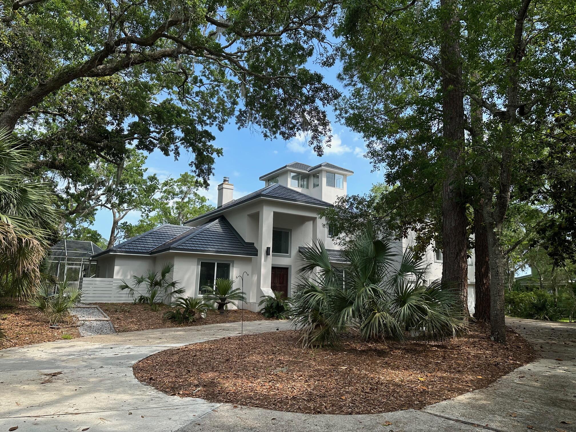 AMAZING VALUE!! JUST REDUCED $145K + PLUS $58K NEW Metal Tile Roof 2025!!!!! BELOW MARKET FOR LOT SIZE AND SQ. FOOTAGE. Waterfront privacy with RARE 1-ACRE containing 167' bay/bayou waterfront. Enjoy sun rises while dolphin, deer & osprey entertain. MAIN HOUSE 1ST FLOOR: Master bedroom suite// Formal Livingroom (convertible to bedroom)// Formal dining (convertible to office)// Soaring Great Room// Large eat-in Kitchen// Large laundry room. LOVELY FOYER STAIRCASE leads to 2ND FLOOR: Master Suite. 3RD FLOOR: Viewing Tower. MAIN HOUSE has two large master bedroom suites. THIRD BEDROOM is located in the APARTMENT above the attached garage which also contains living/dining/kitchen combo & full bath.