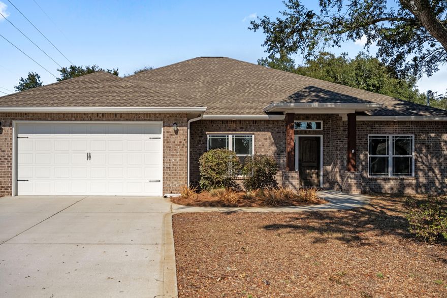 This exquisite well-maintained craftsman 4 bed/2 bath home built in 2018 just may be what you've been waiting for! Boasting a wealth of desirable features and the absence of HOA, this residence nestled in a peaceful neighborhood just 2 miles from Navarre Beach and the Santa Rosa Sound. With just a short drive to the other beaches along the emerald green waters of the Gulf of Mexico. Upon entering, you're greeted by the grandeur of high 11ft Trey Ceilings and elegant archways, showcasing the meticulous attention to detail that sets this home apart. The kitchen is a chef's delight, featuring staggered cabinets with crown molding, stainless steel appliances, and granite countertops - a perfect setting for culinary adventures. The master bedroom is a sanctuary of relaxation with its spacious layout and trey ceilings. The en-suite bath is a spa-like retreat, boasting his and her walk-in closets with custom wooden organizers, a double vanity with granite tops, a rejuvenating garden tub, and a standalone shower. The thoughtful split floor plan situates the additional 3 bedrooms and bath on the opposite side of the home, offering both privacy and convenience. The great room is a spacious haven, complemented by French doors leading out to the 22'x10' covered porch. Imagine entertaining guests in this outdoor oasis, complete with a TV outlet - an ideal spot for grilling and enjoying the Florida sunshine. The vast fully fenced backyard ensures both privacy and security, enhanced by a full irrigation system. For those who love to tinker or need a space for hobbies, a 24x15 workshop sits at the back of the property. Fully equipped with electrical connections and a mini-split AC unit (heated/cooled), this space is versatile and ready for your creative pursuits. The expansive backyard is large enough to accommodate a boat or RV, making it a practical addition for outdoor enthusiasts. This home is not situated in a flood zone. Seize the opportunity to make this beautiful brick craftsman residence your own. Your dream home awaits!