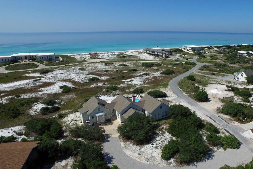 A beautiful home located in the uniquely private, gated historic community of Four Mile Village. This single-level living home is specially situated behind an expansive natural dunescape preserved by the Coffeen Land Trust that affords protected, panoramic views of the Gulf. This home centers around an enormous great room with cathedral ceiling trussed by natural timber beams, whose south-facing wall of windows frames a seaward view over natural dunes laced with scrub oaks and palmetto. Double pocket doors off the main entry foyer can be sealed to partition the master suite from the rest of the home, creating a private front entrance and access to the back porch and full-size in-ground pool.