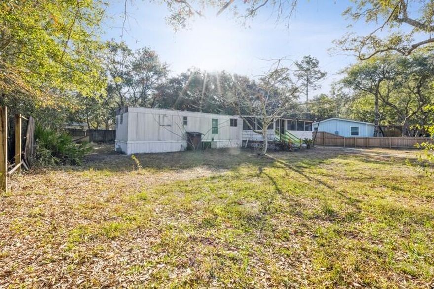 Perfect investment property .Enjoy the large trees on this secluded lot that is still only minutes to the beach, grocery stores, and restaurants. This is by far one of the most affordable places to live in Navarre. mobile home conveys with land.