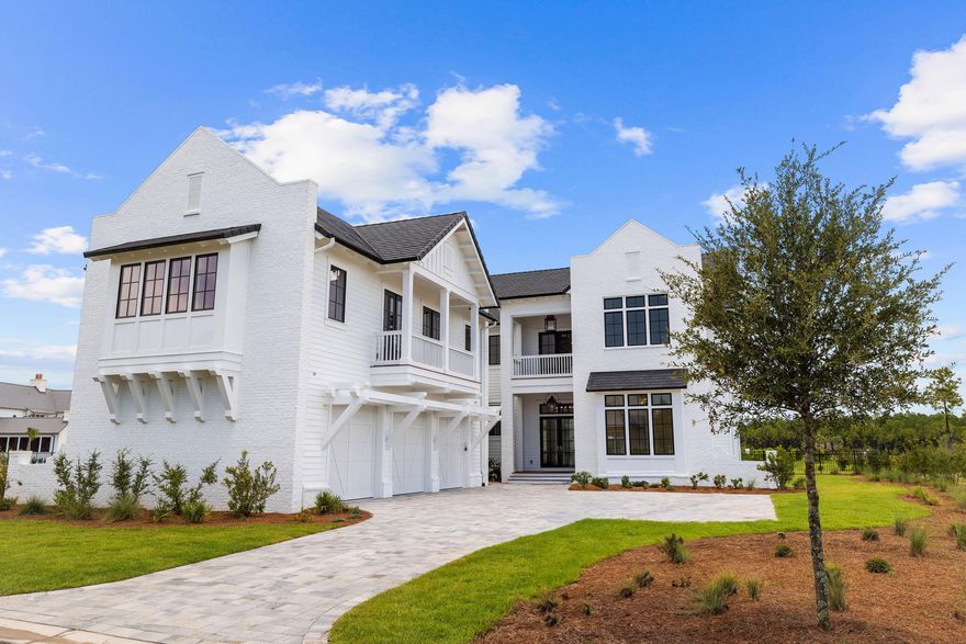 This stunning new construction home in WaterSound combines a luxurious lifestyle with the joys of lakefront living. Designed by renowned architect Chris Stoyles of Archiscapes and showcasing stunning furnishings and interiors by Bontemps Interiors, this 5,600-sq.-ft. residence includes a spacious carriage house above the three-car garage. Two living areas with floor-to-ceiling windows frame serene water views to the rear of the home. Completed in 2024, everything is pristine, from the contemporary chef's kitchen to the bubbling waters of the private pool. With its retractable NanaWalls, the sitting room invites you to put your feet up in front of the floor-to-ceiling fireplace and savor contentment. Shiplap walls and hardwood plank flooring continue through the open kitchen to the dining room with lake views on two sides. The gourmet kitchen is avant-garde, with a textured tile backsplash and a dining island wrapped in Calacatta veined quartz. Veneered Milano doors add a contemporary touch to the cabinetry and extractor hood. Wolf and Sub-Zero appliances include a wine cooler and a six-burner gas stove with a double oven beneath. The butler's pantry has a second refrigerator, freezer drawers, a dishwasher, a Wolf warming oven, an ice maker and additional storage. Doors open onto the decked porch with a cozy outdoor fireplace. Beyond that, a verandah provides the perfect alfresco dining setting. Take a morning dip in your oversized private pool, relax in the spa and watch herons and wildlife just beyond the fence. A cabana with a fully equipped summer kitchen makes entertaining easy with its dedicated sink, grill and built-in refrigerator. The pool house includes an outdoor shower. The first-floor master suite has multiple windows surrounding a tranquil view. The customized walk-in closet/dressing room will indeed create home envy, along with the spacious master bathroom. It has a stunning tiled shower and an oval garden tub, creating a holistic escape from everyday stress. The second floor is uplifting with a den, office and three more bedrooms, all with private baths. There's also a covered porch for sunset views. Honored guests can stay in the 1,000-sq.-ft. carriage house. It has a private sitting room, bedroom, bathroom and laundry. The full kitchen is equipped with Fisher & Paykel appliances. This lavishly appointed home is pre-wired for home automation system and has a DaVinci roof with 50-year warranty. It includes a WaterSound Club membership, guard-gated security and a host of lake, beach, golf and sporting amenities.  