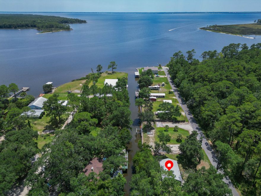 Old Florida at its best! This relaxing waterfront cottage, located in an X Flood zone sits on 2 lots with 120 ft. of canal waterfront. The canal leads directly to Alaqua Bayou then to the Bay. Upgrades include windows, water heater, roof, septic tank, drain field and ac unit. 2025 upgrades new flooring, exterior doors and dock replaced. Have the privacy of being close to the Bay, Eglin AFB, and convenience of being less than 5 minutes to two boat launches, Horsepower Pavilion and Dollar General.  Less than 10 minutes to Publix. Plenty of room on the lot for Kayak, paddle board, boat and RV storage. Enjoy the beauty of pristine nature at its best.  Grab your paddle board or boat and step back in time exploring the many unspoiled coves and creeks of this Old Florida paradise!