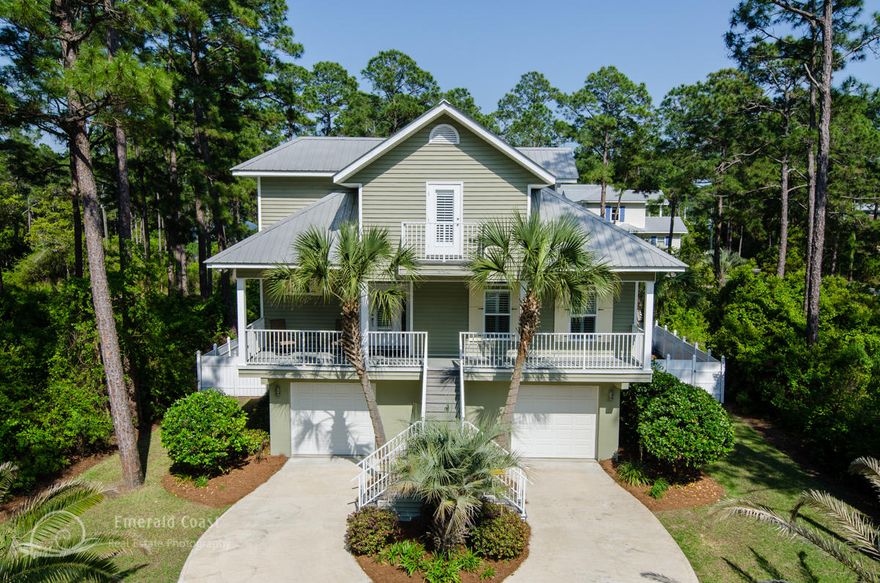 Stunning Southern Coastal home designed in the low country style featuring outdoor living spaces, covered porches, an open floor plan and a feeling of relaxed elegance. The fresh, modern style furniture is offered with the property. The oversized lot allows for a large pool with waterfall, hot tub, sunken bar stools, brick paver pool deck and privacy fence around the entire backyard. Located within walking distance to a Coastal dune lake and the Gulf of Mexico. The concrete block-construction first floor has two oversized garages that could easily be converted into more living space or a lockout/mother in law suite supported by an interior stairwell. The living area is open with cathedral ceilings, gas fireplace and an easy flow into the kitchen and dining area.