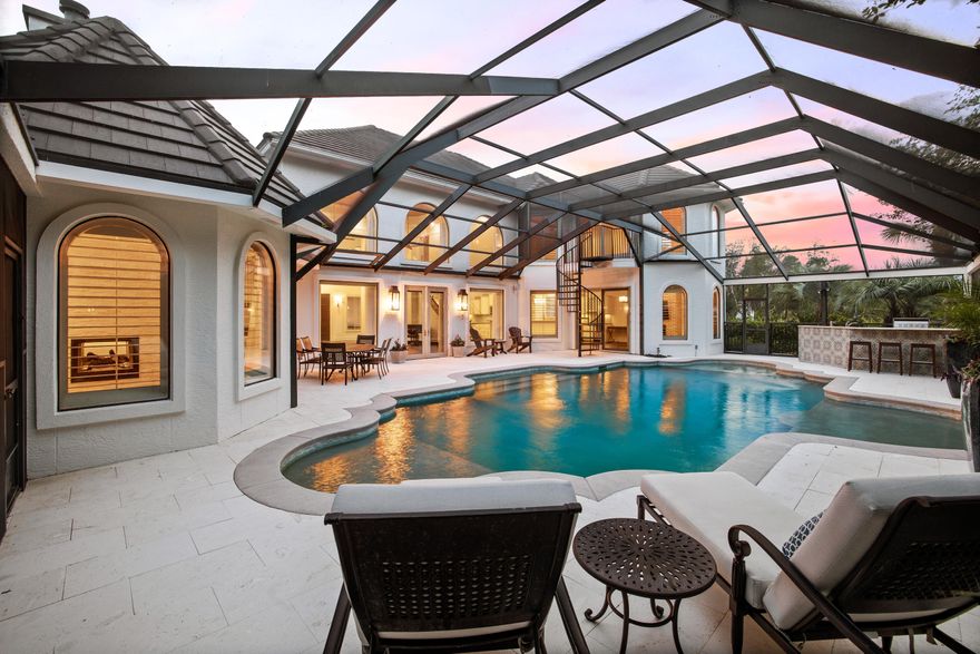 Tucked inside of the gated community of Regatta Bay sits this renovated waterfront Spanish-style estate. This stunning residence is perfectly positioned on the lake and just a short stroll from the bay. Upon entry, you are greeted by the spacious living room with 22' ceilings, a beautiful brick fireplace, and floor-to-ceiling windows flooding the room with natural light. the open floor plan allows for seamless entertaining and connects the living room to the kitchen and dining area. The chef's kitchen features dual ovens, a gas stove, oversized island, dual sinks, and a wet bar with an ice maker and wine cooler. The dining room showcases a brick fireplace and views of the stunning outdoor living area.
