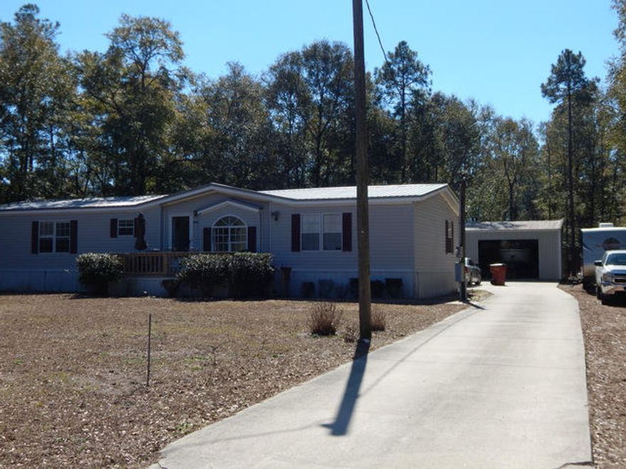 Beautiful and well maintained manufactured home on 2 acres with a wonderful 30x24 workshop. There are 3 large bedrooms laid out in a split bedroom floor plan. The kitchen is very spacious with a center work island, breakfast bar and down draft range. Stainless steel refrig. is newer. The kitchen is open to the dining area. The great room is light and bright, has a vaulted, beamed ceiling and is 25x16! Outside you will find a piece of paradise with 2 acres, mostly treed for privacy and fun. The workshop is fully equipped with 110 and 220 power, concrete flooring, insulated and roll up door. The back yard is separately fenced from the rest of the land for kids and pets. There is also a nice storage building out back & a long concrete driveway. Take a closer look at this home before it's SOLD